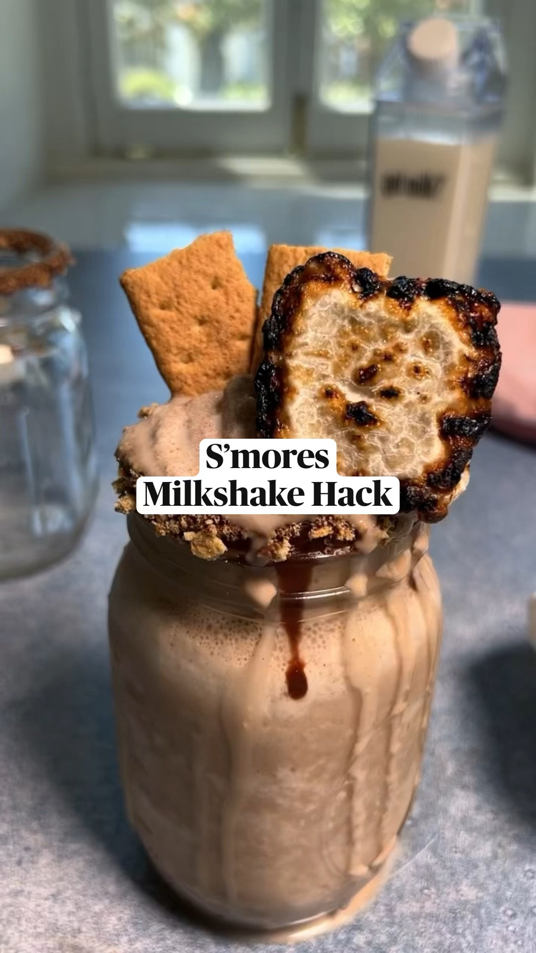 INGREDIENTS 2% Milk 3 tbsp Chocolate Syrup 7 Graham Crackers ¼ cup Chocolate Chips 2 tsp Coconut oil 1 Marshmallow INSTRUCTIONS Fill ice cube containers with milk and freeze until solid. Roast marshmallow as desired Microwave chocolate chips and coconut oil in 10-second increments until melted. Crush two graham crackers into fine pieces in a plastic bag. Dip the rim a mason jar into melted chocolate and coconut oil mixture, and then dip into crushed graham crackers. Add 3 frozen cubes to a blender. Drizzle chocolate syrup and add 4 graham crackers. Pour in ⅓ cup of milk and blend until smooth. Pour milk “smoothie” into jar, top with 2 graham cracker halves and toasted marshmallow.

#LTKHome #LTKStyleTip #LTKSeasonal