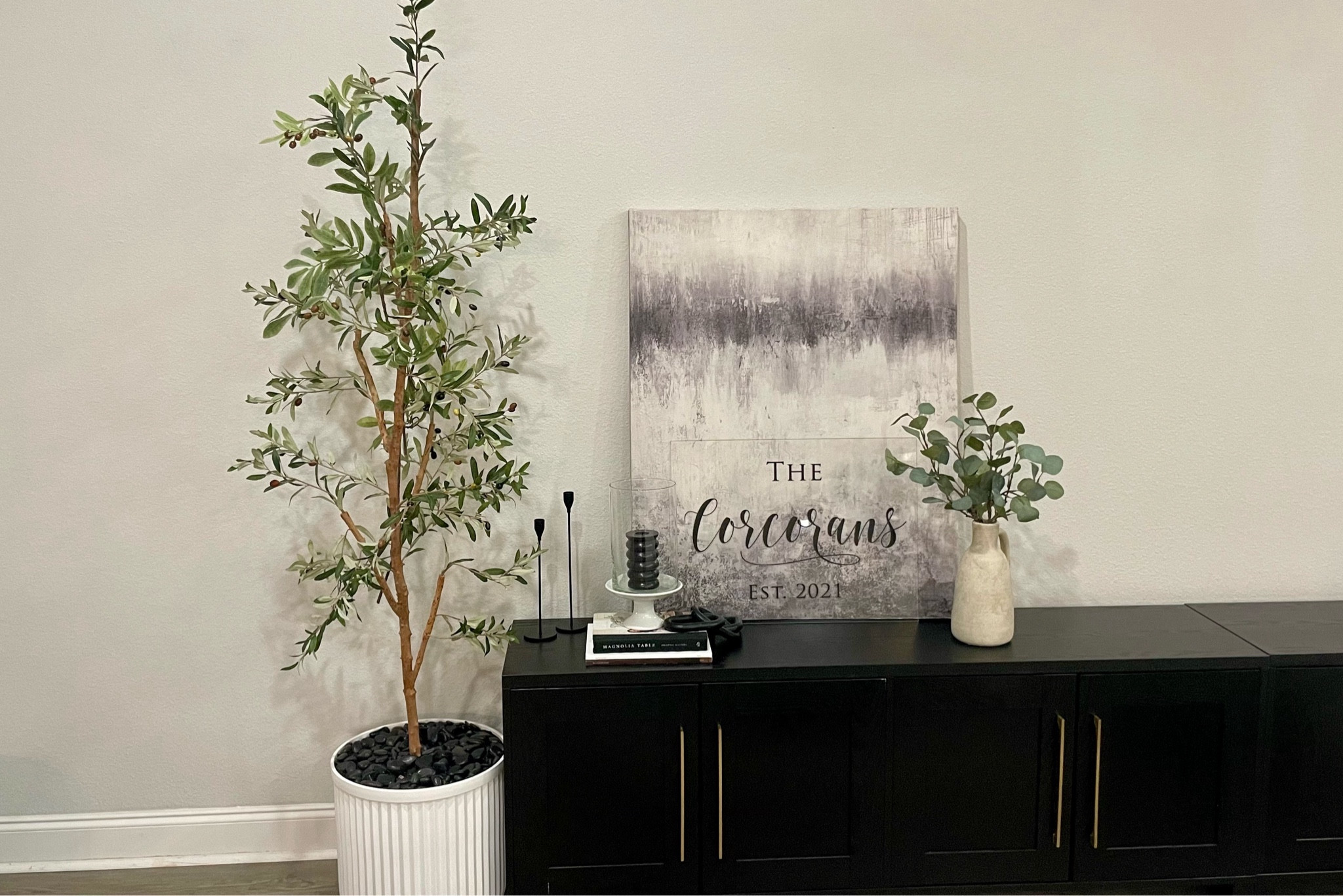 Modern living room decor! I love this black modern tv stand paired with my large 6 ft olive tree! The tree and sidebord are from Amazon, and the white planter is from Walmart! I paired it with some large canvas art from hobby lobby. 

Happy Friday! 

#tvstand #sideboard #consoletablestyling #consoletable #olivetree #whiteplanter

#LTKfindsunder100 #LTKhome #LTKsalealert