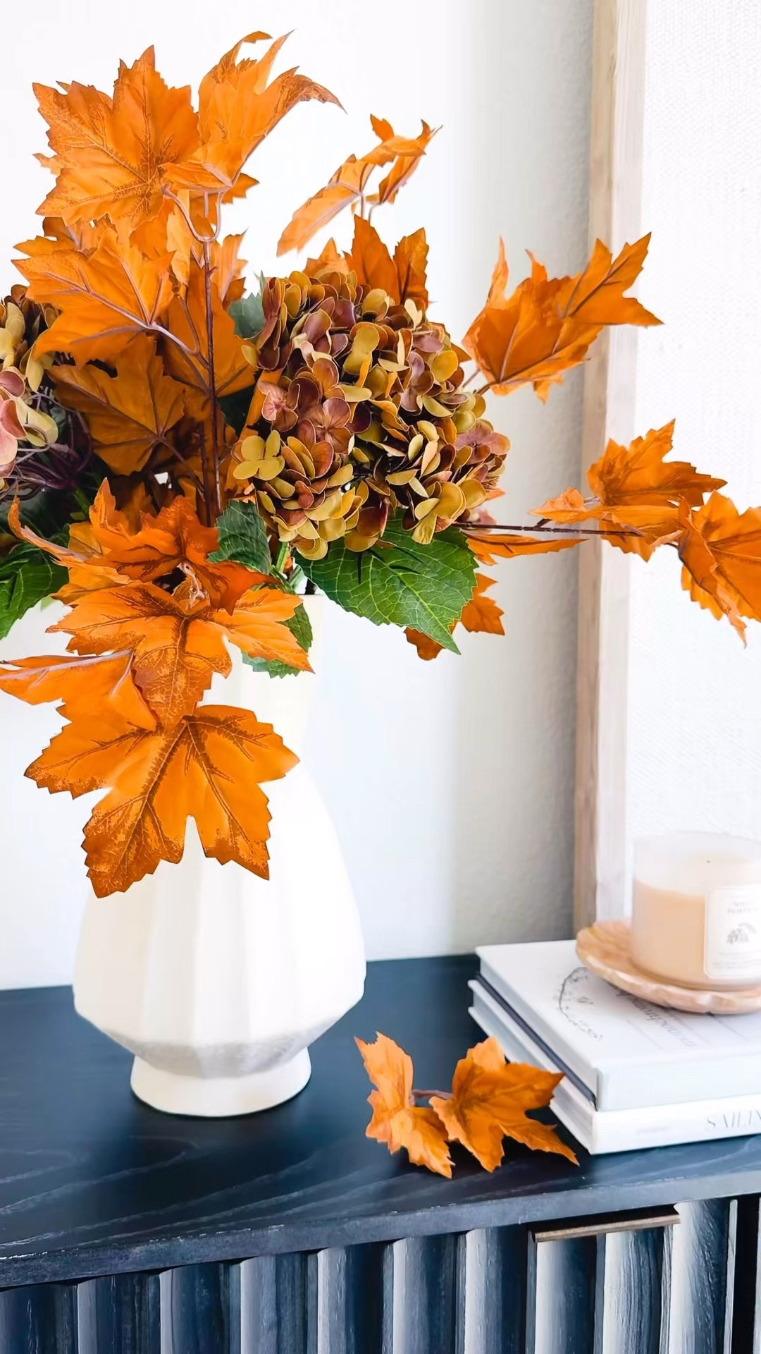 A few simple fall decor touches made this console feel so cozy for the season, and these maple leaf stems are a Walmart find! 🍂 I mixed these yellow orange maple leaf stems with warm-toned hydrangeas from Amazon to create a fuller fall floral arrangement, then kept the rest of the console styling simple with a neutral vase, stacked coffee table books, a fall candle and a few warm brass accents. Such an easy way to bring in those rich autumn colors without completely changing your space. Linking the Walmart fall stems and the rest of my fall home decor finds for anyone looking for simple fall decorating ideas, fall console table decor, cozy fall home inspiration, faux fall stems and affordable fall decor.

#LTKHome #LTKSeasonal #LTKSaleAlert