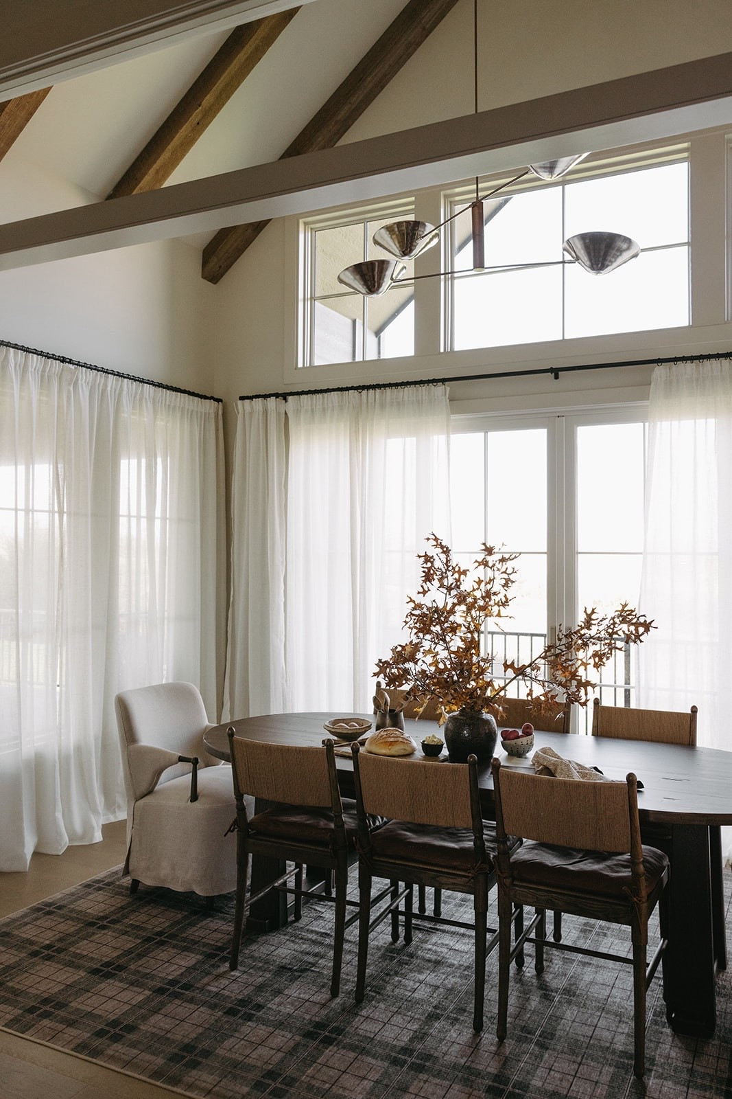 Dining room linear chandelier light fixture 
Wood oval table 
Dining chairs 
Curtains 
Plaid rug Ruggable 

#LTKstorytime #LTKHome #LTKSeasonal