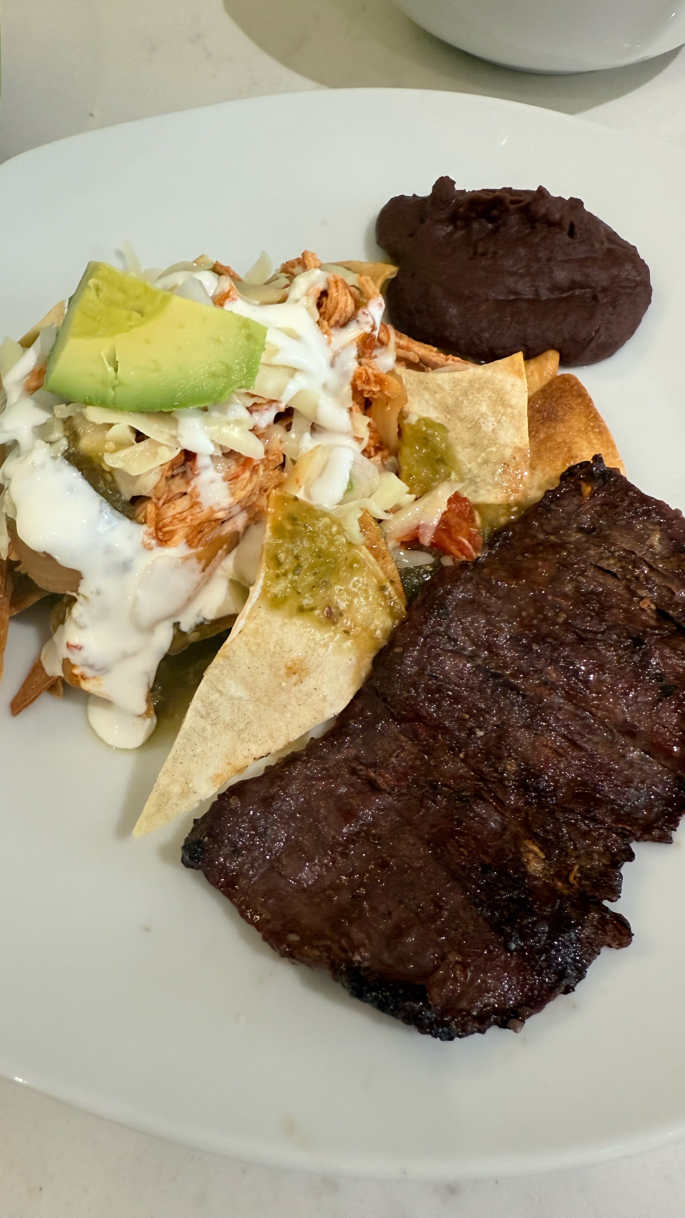 Air-Fried Chilaquiles Verdes with Shredded Chicken

Crispy air-fried tortilla chips smothered in tangy salsa verde, topped with tender shredded chicken, cheese, and avocado—perfect for breakfast or brunch!

Ingredients

For the Tortilla Chips:
	•	14 corn tortillas, cut into pieces
	•	2 tbsp olive oil

For the Salsa Verde:
	•	10 tomatillos, husked
	•	3 serrano chiles
	•	½ onion
	•	5 garlic cloves
	•	½ cup cilantro

For the Shredded Chicken:
	•	2 chicken breasts, cooked & shredded
	•	½ onion, sliced
	•	1 tsp oregano
	•	½ tsp cumin
	•	Salt & pepper
	•	1 tsp chicken bouillon
	•	1 can (14 oz) San Marzano tomatoes
	•	1 tsp garlic paste
	•	1 tbsp olive oil

For Assembling:
	•	Queso fresco or shredded cheese
	•	1 avocado, sliced

⸻

Instructions

1. Air-Fry the Tortilla Chips
Preheat air fryer to 375°F (190°C). Toss tortillas with olive oil, arrange in a single layer, and air-fry for 10 minutes, shaking halfway. Set aside.

2. Make the Salsa Verde
Boil tomatillos, chiles, onion, and garlic for 10 minutes. Blend with cilantro until smooth.

3. Cook the Chicken
Sauté onions in olive oil. Add oregano, cumin, salt, pepper, chicken bouillon, and garlic paste. Stir in San Marzano tomatoes, cook for 5 minutes, then add shredded chicken and simmer 5 minutes.

4. Assemble
In a skillet, toss tortilla chips with warm salsa verde. Top with shredded chicken, cheese, and avocado slices. Serve immediately!

⸻

Enjoy these chilaquiles verdes with a fried egg or refried beans! Let me know if you try this recipe.
#adrismexicankitchen


#LTKFamily #LTKHome #LTKParties