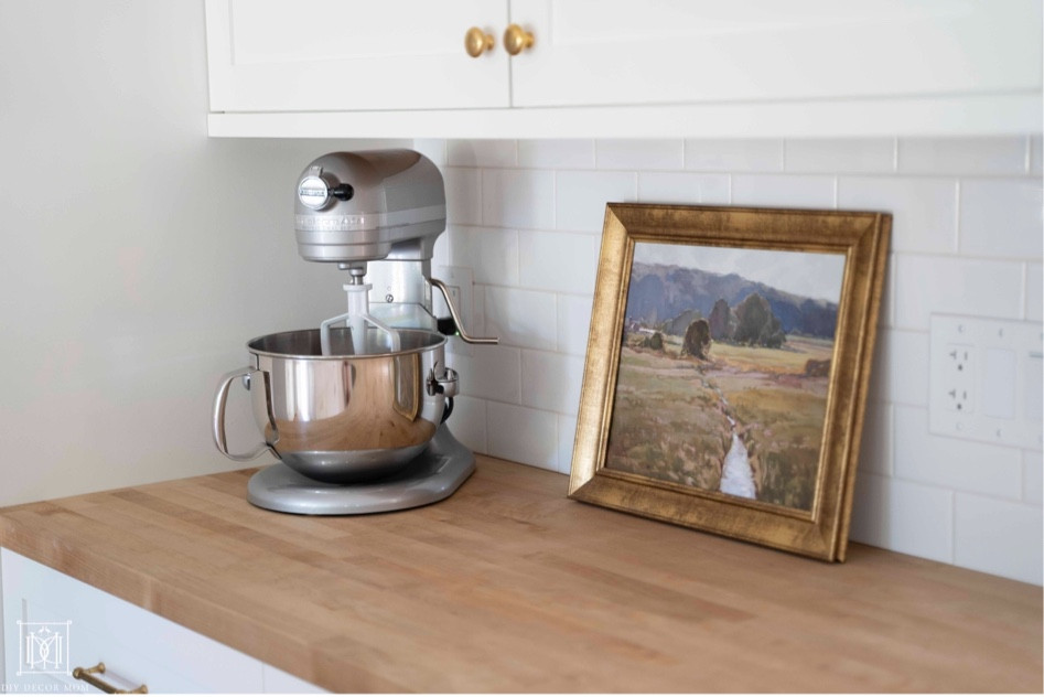 Kitchen Target artwork and stand mixer butcher block countertop, brass knobs
