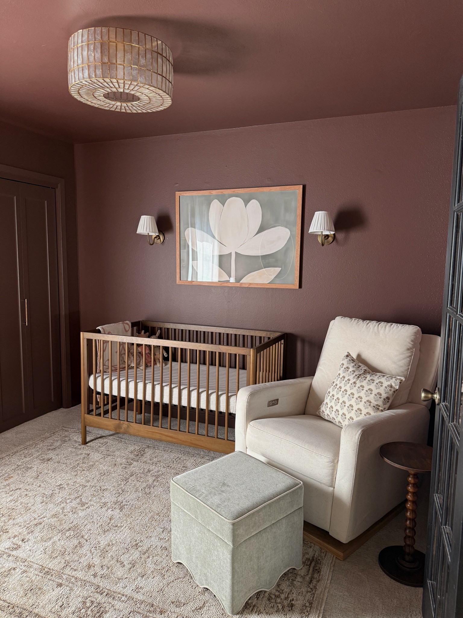 Moody, vintage, modern style baby girl’s nursery. Large floral wall art, wood crib, the best recliner, ottoman, area rug, brass sconces, capiz shell drum semi slush mount light, floral throw pillow.

#LTKBaby #LTKHome
