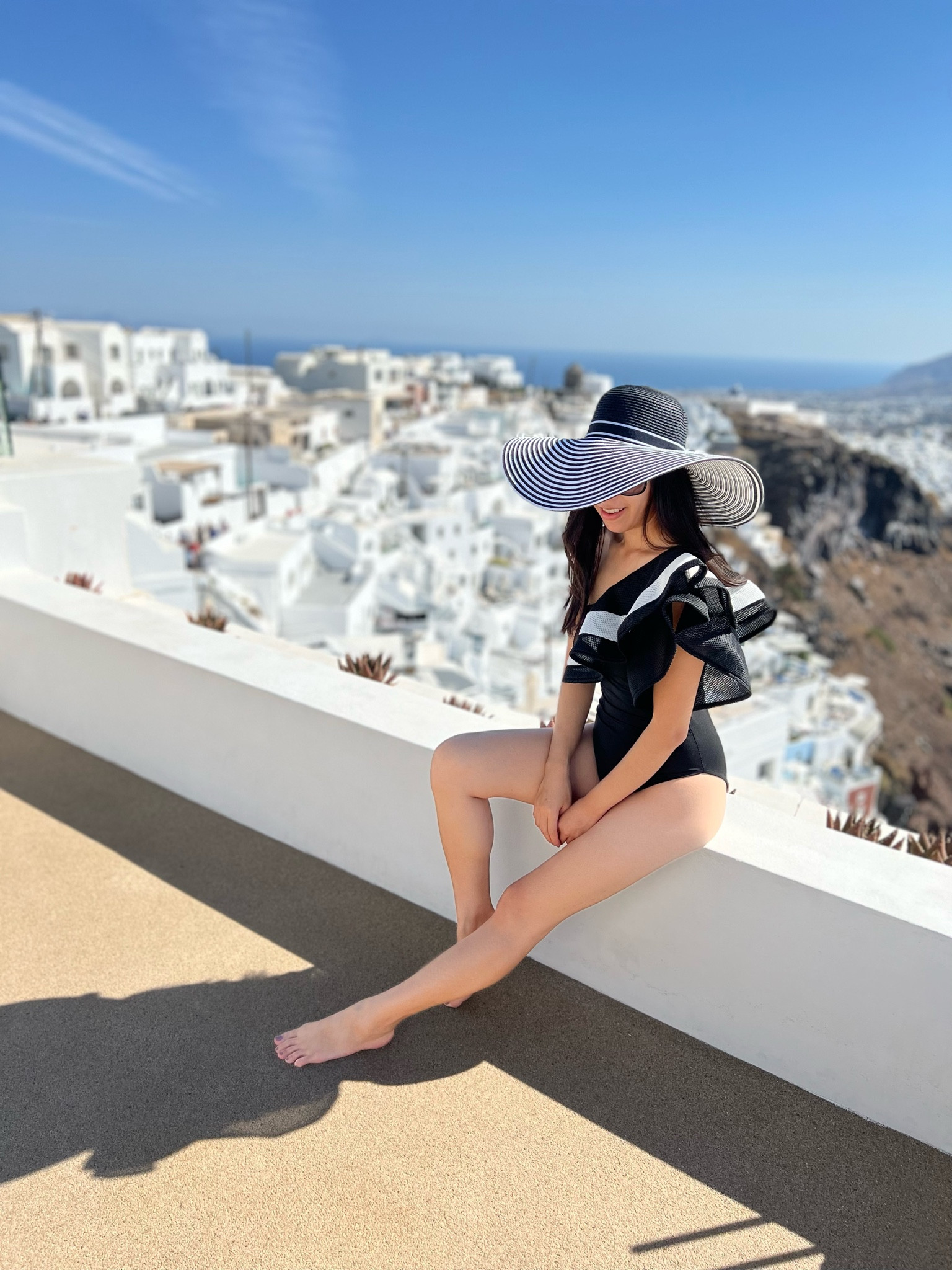 Dreaming of Santorini! This was taken at the second place my mom and I stayed at. It was a 3 story suite with unobstructed views of the island! From this third story floor, we even saw the infamous blue Imerovigli dome everyone poses with (not pictured here) - we were just a few steps away from it! This was a prime location since it was near all the tourist hot spots yet it was tucked away and had a private entrance. For this beautiful day, I wore a one shoulder ruffled black and white swimsuit with a floppy hat. I still have numerous unposted pictures of my vacation so stay tuned! 

#LTKFind #LTKswim #LTKunder50