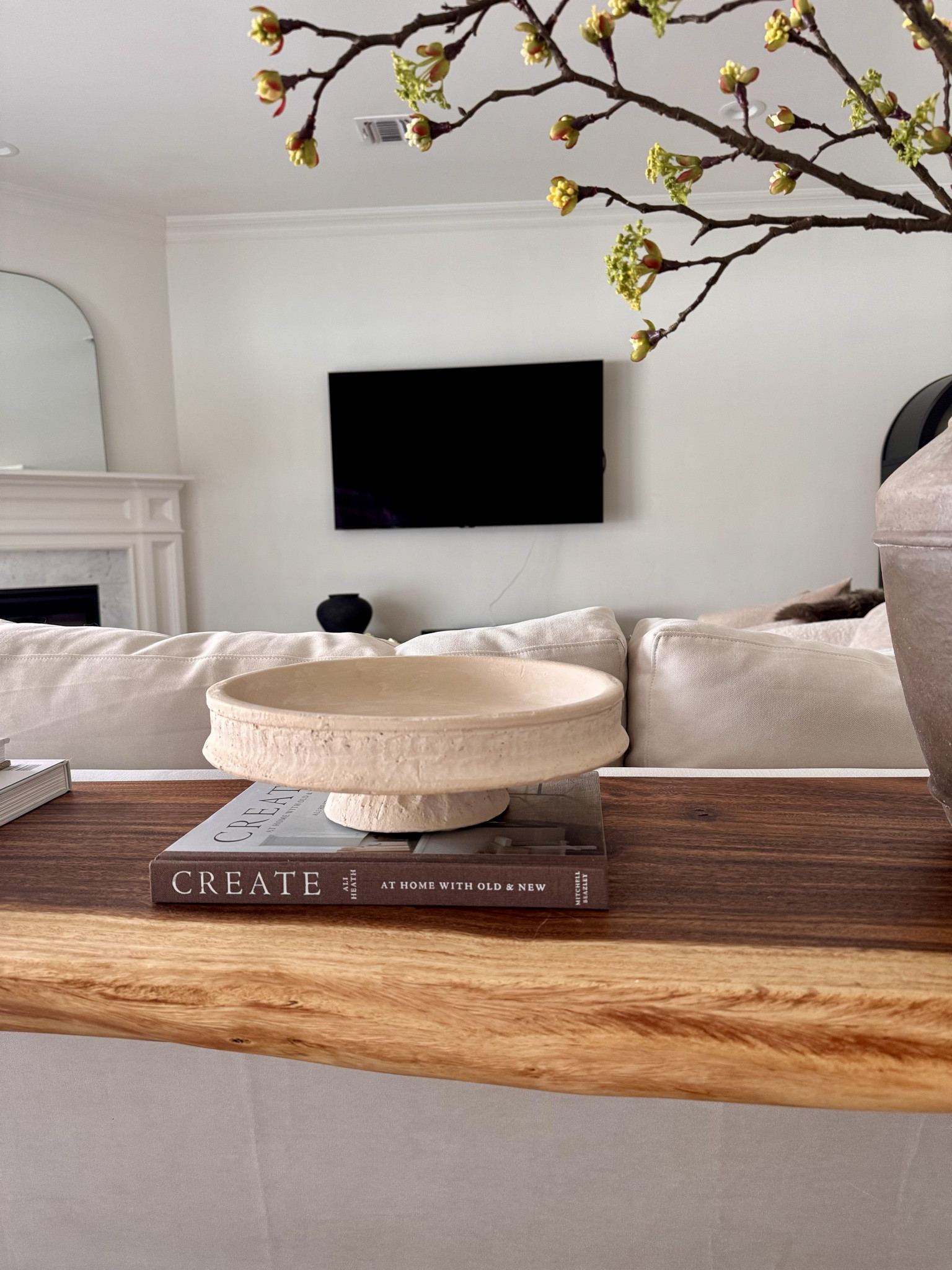 A stone pedestal bowl layered over design books adds height, texture, and quiet character to a console or sofa table.

#consoledecor #stonebowl #pedestalbowl #decorbooks #neutraldecor #woodfurniture #livingroomdecor

#LTKSeasonal #LTKHome #LTKFindsUnder50