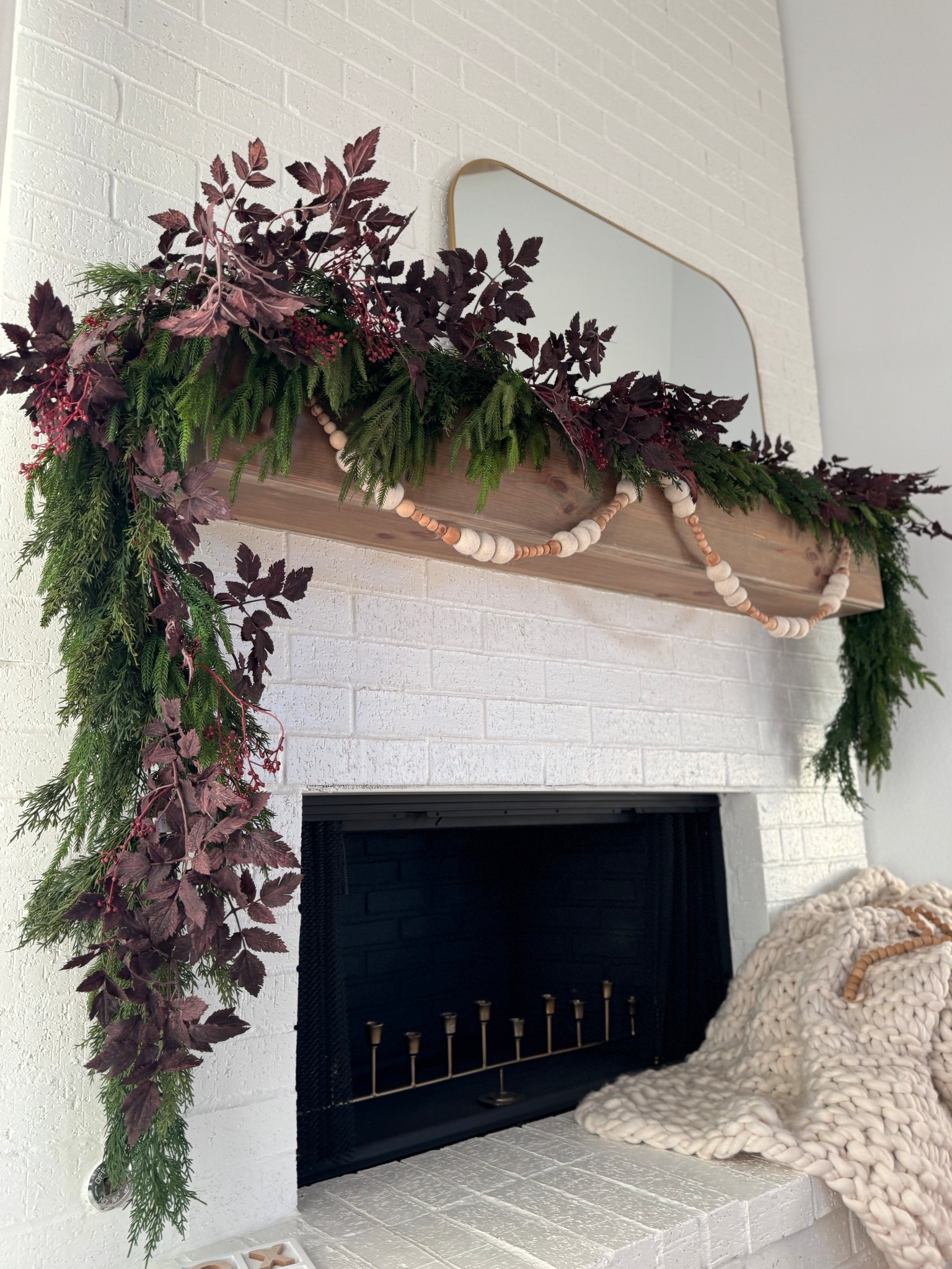 ✨ Mantel magic ✨ I’m all about layering textures this season — a mix of cedar greens, deep burgundy foliage, and wood bead garland for a natural, elevated look. Sometimes it’s the simple details that make a space feel warm and inviting. 🕯️🍂

Would you decorate with bold foliage or keep it classic green? 🌿

#Falldecor #halloweendecor #thanksgivingdecor #homedecor 

#LTKStyleTip #LTKSeasonal #LTKHome