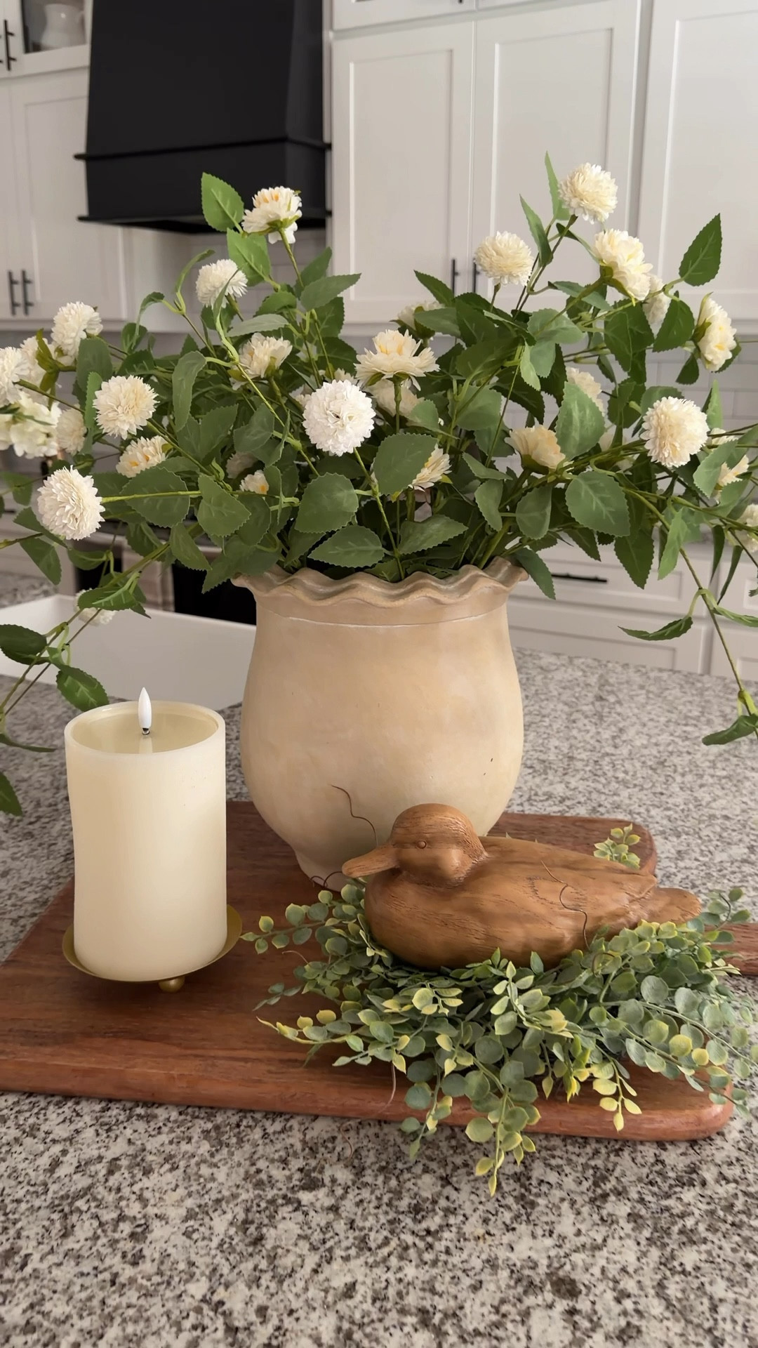 I love how this arrangement came together. 🥰  I used my large breadboard as the base to really ground everything, then layered in these gorgeous pom stems in a scalloped vase—they are so good! I added a candle ring for my little duck to sit on and finished it off with a soft flameless candle glow.

Such an easy, beautiful look that works perfectly for both Spring and Summer! ☀️