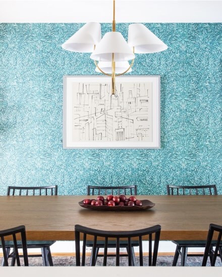Some dining rooms are reserved for holidays, but this isn’t one of them.

For this family, the dining room is where just about everything happens; family dinners, homework after school, weekend projects, and catching up at the end of the day.

We wanted the space to reflect that. A larger table better suits the way they gather, updated lighting brings warmth to the room, and a leafy wallpaper adds personality while tying everything back to the rich teal tones in the front living room.

Tucked off to the side, a dedicated whiskey bar gives a nod to one of the homeowners’ favorite ways to unwind, making the space feel even more personal.

Beautiful spaces should be lived in, and this one certainly is.