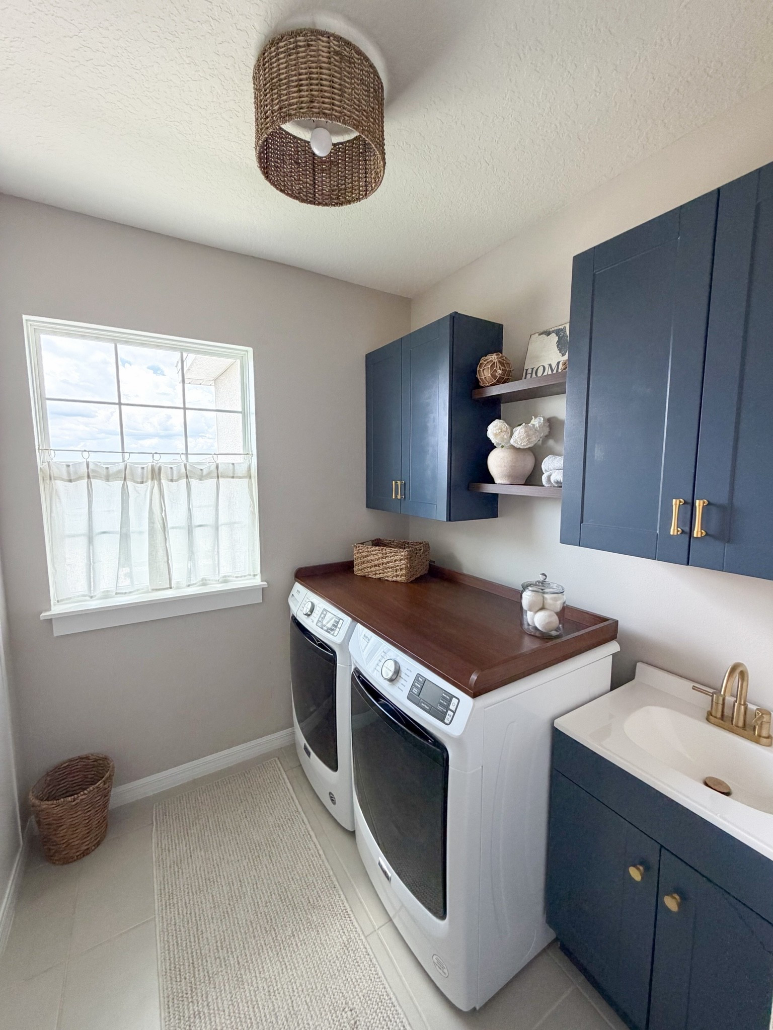 A laundry room that works hard and looks good doing it. ✨

Blue cabinets, a custom washer and dryer countertop, dark wood shelves, gold hardware and faucet, woven accents, and glass storage jars came together to create a space that feels both functional and beautiful.

Paint color: StainMaster Classic Blue Cabinet Paint

Shop the details on LTK. 🤍

#laundryroom #laundryroommakeover #laundryroomdesign #homedecor #interiordesign #laundryroominspo #homesweethome

#LTKHome #LTKHome