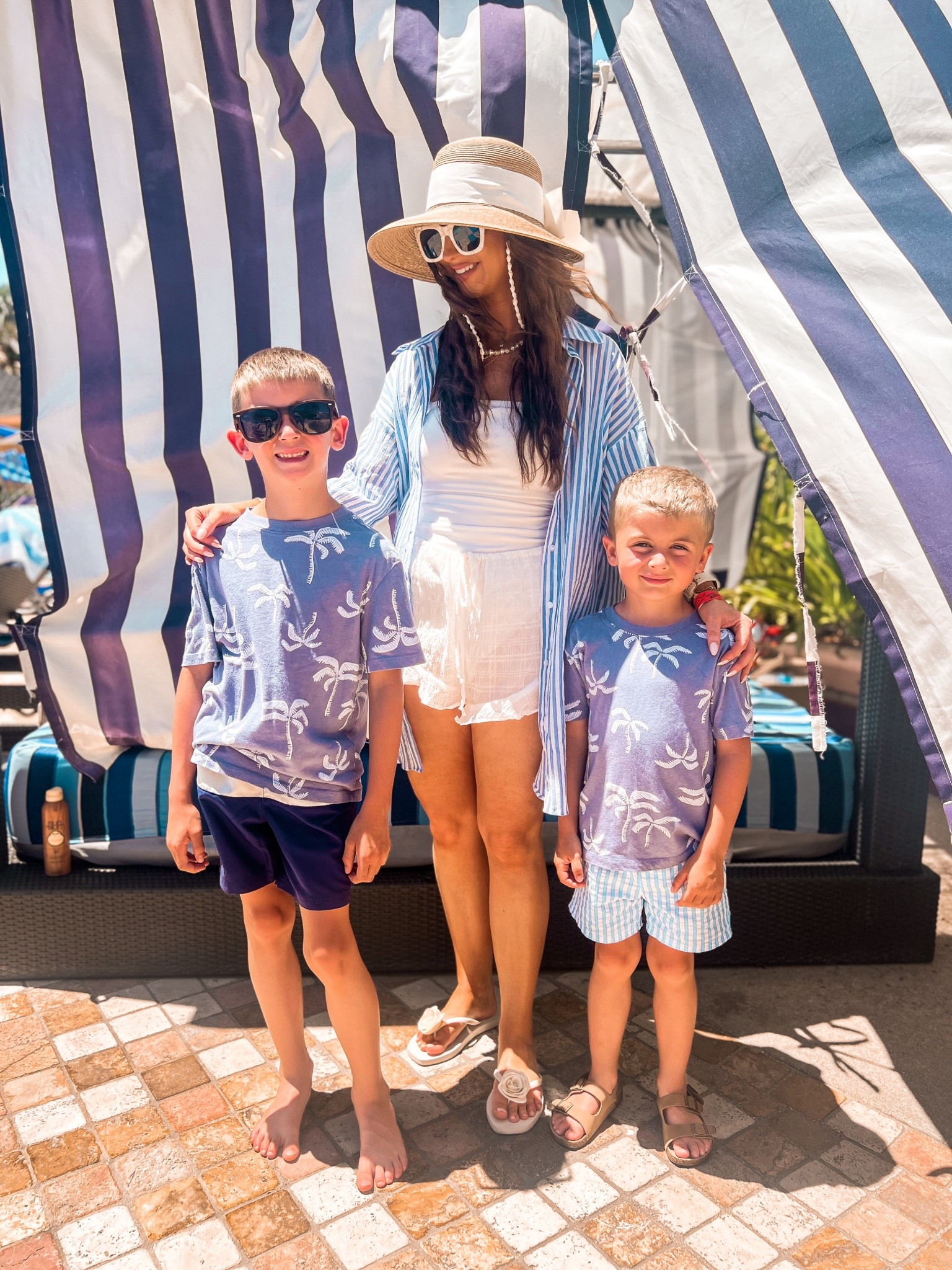 Coastal family beach pool outfits
Boys blue and white beach outfits
Womens white ribbed one piece swimsuit
Womens white ruffle swim coverup shorts
Womens sun hat with white bow on back 
Boys blue and white tropical palm tree shirt
Women’s white and blue striped gauze button up swim coverup shirt
Boys blue and white swim trunks 
Womens white sunglasses 
