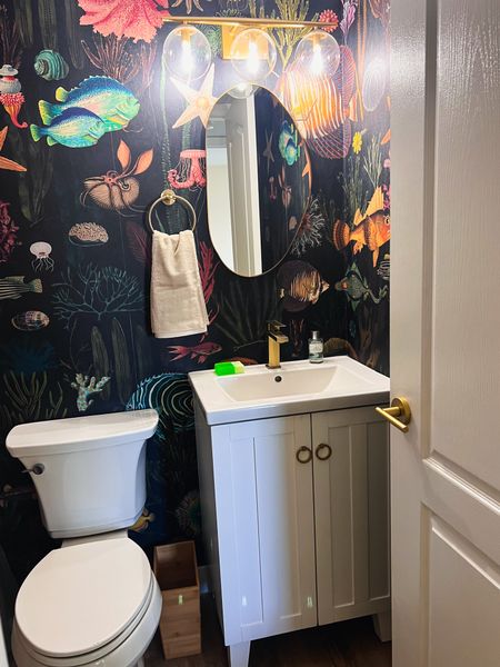 Under the sea guest bathroom 🐠 
To transform the guest bath of my Miami condo, I chose to keep the original tile and tub. I then added a vinyl floor, this really cool fish wallpaper, a new vanity from wayfair and gold accessories from Amazon to spruce it up. 

#beachdecor #beachhouse #beachcondo #bathroomreno 

#LTKSeasonal #LTKhome #LTKstyletip