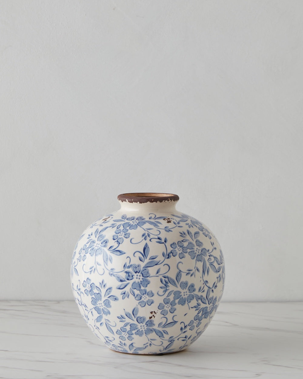 Blue floral decorations evoke a traditional style with delicate elegance in this terracotta vase. The antique finish and timeless design offer a touch of sophistication to any transitional look, whether styled alone or filled with a botanical arrangement.

#LTKHome #LTKSeasonal