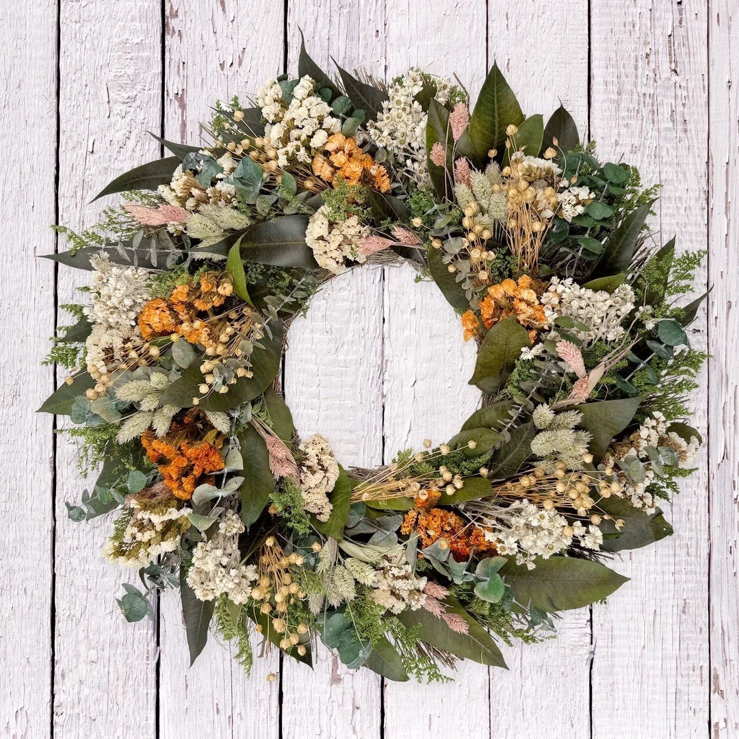 Bring natural warmth to your home with this handcrafted dried floral wreath made with flowers, eucalyptus, and grapevine for an organic, textured look. The soft orange, green, and white tones make it perfect for spring, summer, or year-round styling. Beautiful on a front door, entryway, or wall, this timeless piece arrives safely in a protective wood crate and is ready to display.

#LTKHome #LTKStyle #WreathDecor #DriedFlowers #SeasonalDecor #FrontDoorDecor #FarmhouseStyle #NaturalHome #SpringDecor #SummerDecor #HomeDecorFinds #LTKFinds 

#LTKHome #LTKSeasonal