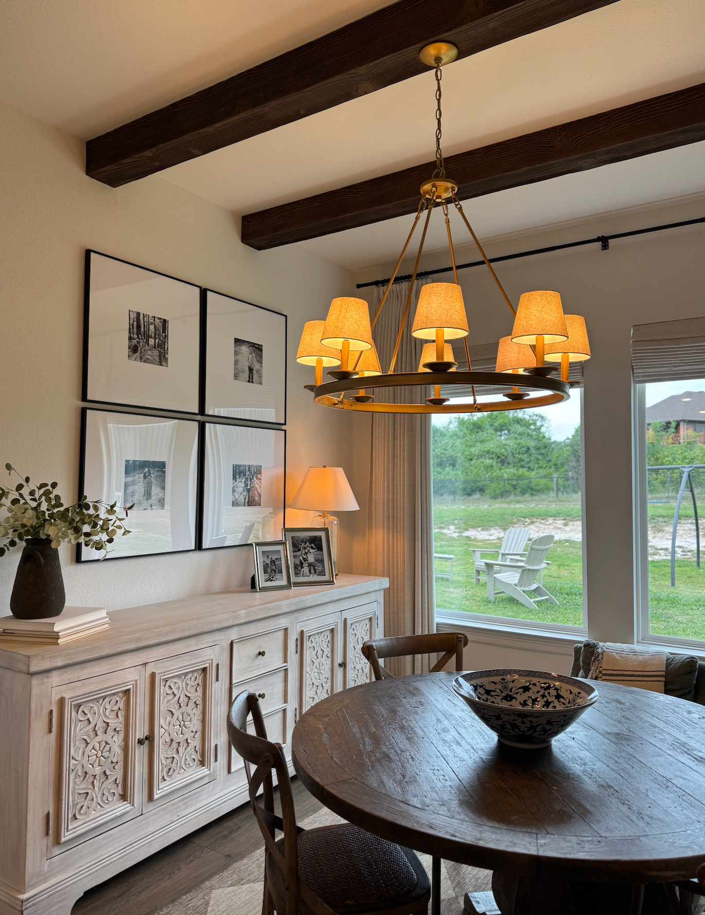 Dining room decor | Dining room inspiration | Round dining table | Wood dining table | Dining chairs | Dining room chandelier | Brass chandelier | Statement lighting | Traditional home | Transitional home | Collected home | Timeless interiors | Warm neutral home | Dining room styling | Sideboard decor | Buffet styling | Gallery wall | Family photo wall | Faux wood beams | Ceiling beams | Curtains | Window treatments | Cozy home | Nancy Meyers style | Classic home decor 

 #LTKmomlife #LTKHome #LTKSaleAlert
