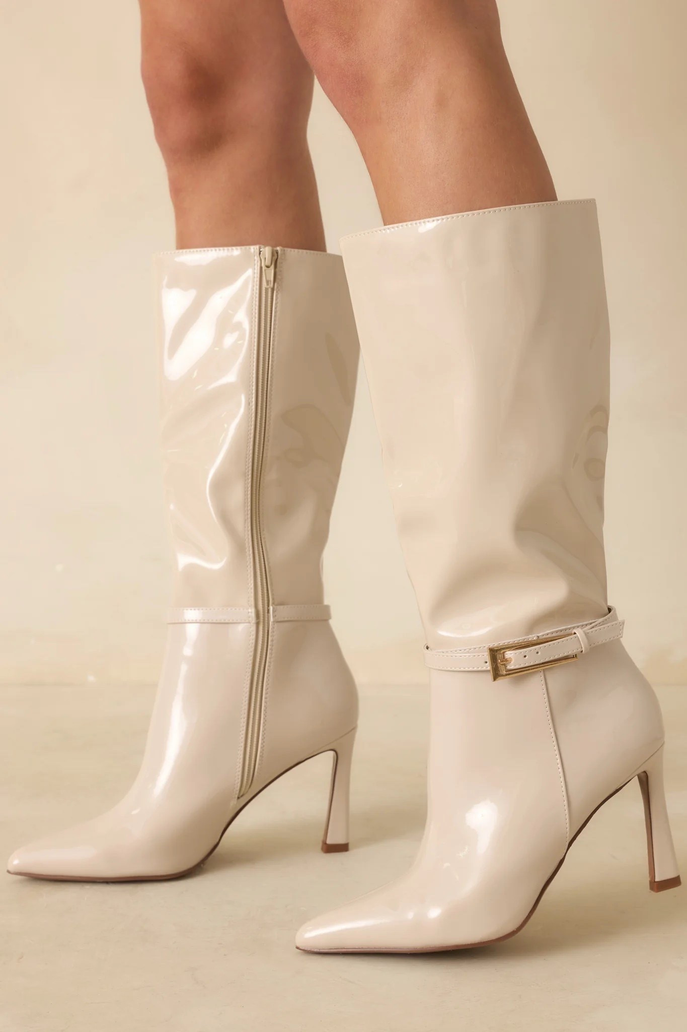 Bring the drama with every step in the Stay In Touch Ivory Patent Faux Leather Boots. Crafted from glossy ivory patent faux leather, this pointed-toe pair features a sleek stiletto heel and polished gold buckle detail that instantly elevates your look. Whether paired with denim or your favorite mini, they’re made for nights that don’t end early. These ivory patent faux leather boots feature a pointed toe, stiletto heel, and mid-calf height with a gold buckle strap detail. Finished with a side zipper closure and synthetic lining. Under $80.

Heel measures 3.5"

Keywords: Faux leather boots, leather boots, knee high boots, workwear boots, women’s leather boots, suede booties, ankle booties, suede boots, booties, croc boots, winter outfits, winter leather boots

#LTKgrwm #LTKWorkwear #LTKootd