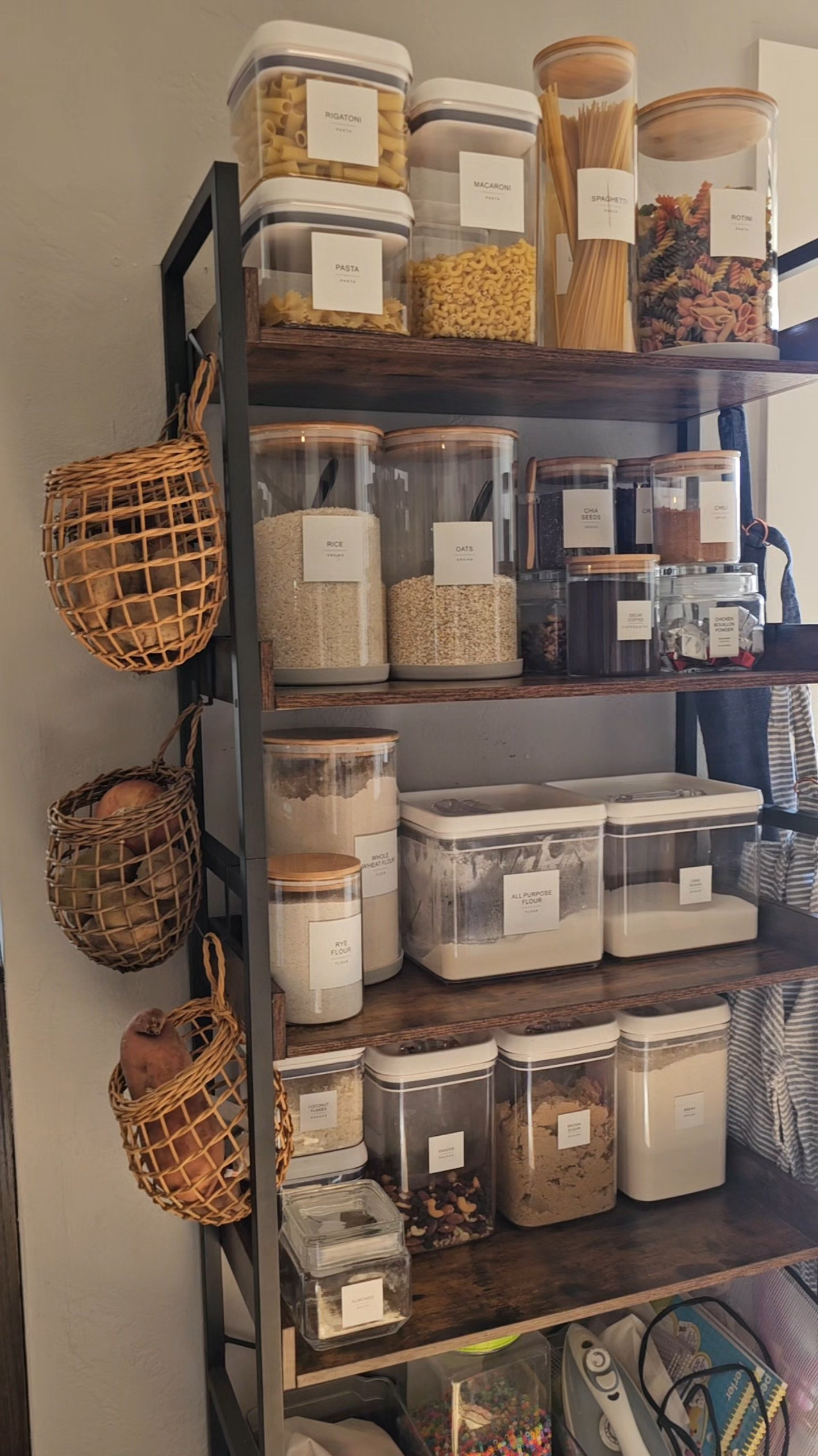 We didn't have a big walk-in pantry, so we used this open shelving unit instead! With some glass jar containers and pretty labels, it looks pretty great - don't you think? I love the onion and potato baskets hanging on the sides. #pantry #pantryshelves #kitchen 

 #LTKHome