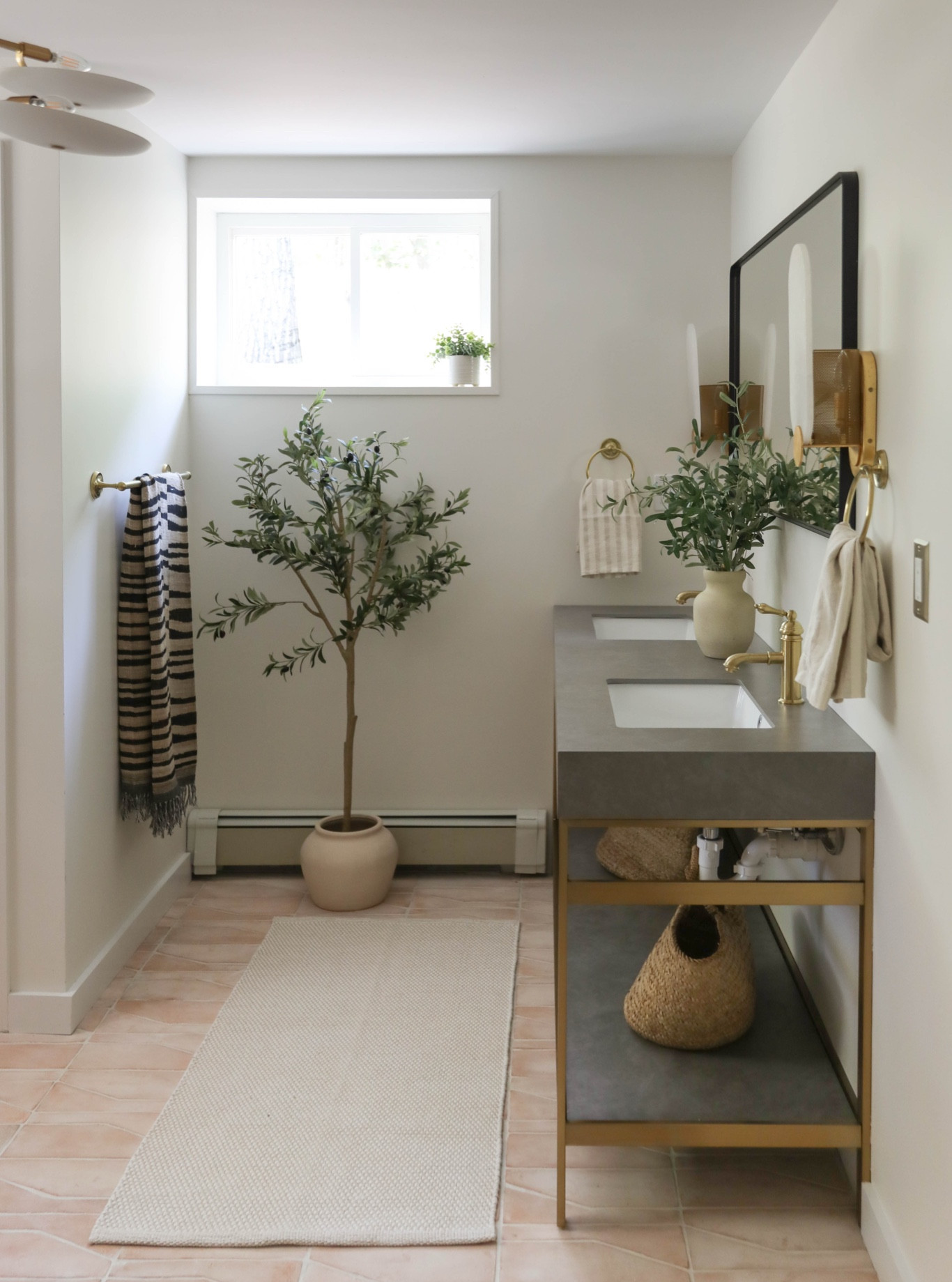 Bathroom with a double sink, stone top vanity, and brass fixtures. Added a runner, wall-mounted mirror, and simple storage below. Linking similar and exact pieces here.

#LTKHome #LTKSaleAlert
