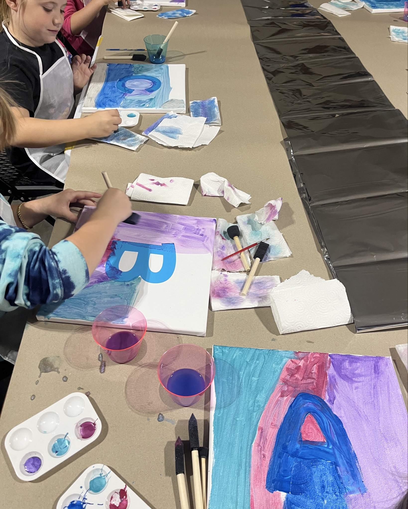 My daughter’s canvas painting birthday party was so fun! We set up tables in our garage, covered with brown paper and set up a station for each girl. I cut out the letters with my Cricut Maker ahead of time, they painted them, then pulled off the letters at the end. Such a fun birthday party craft! Was a big hit with second graders. This was the big activity during her Kpop Demon Hunters birthday party  

#LTKFamily #LTKKids #LTKParties
