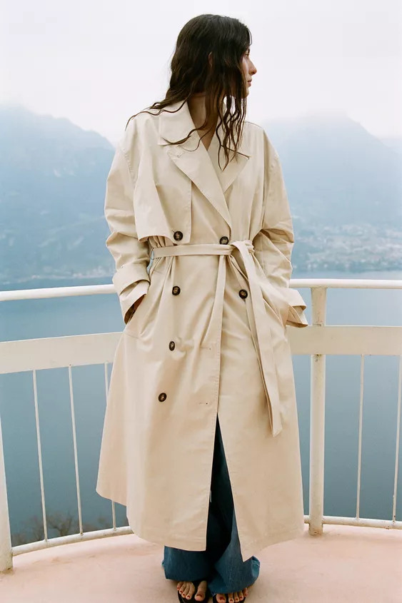 Oversized trench coat crafted from a cotton blend. Lapel collar and long sleeves with adjustable ... | Zara US