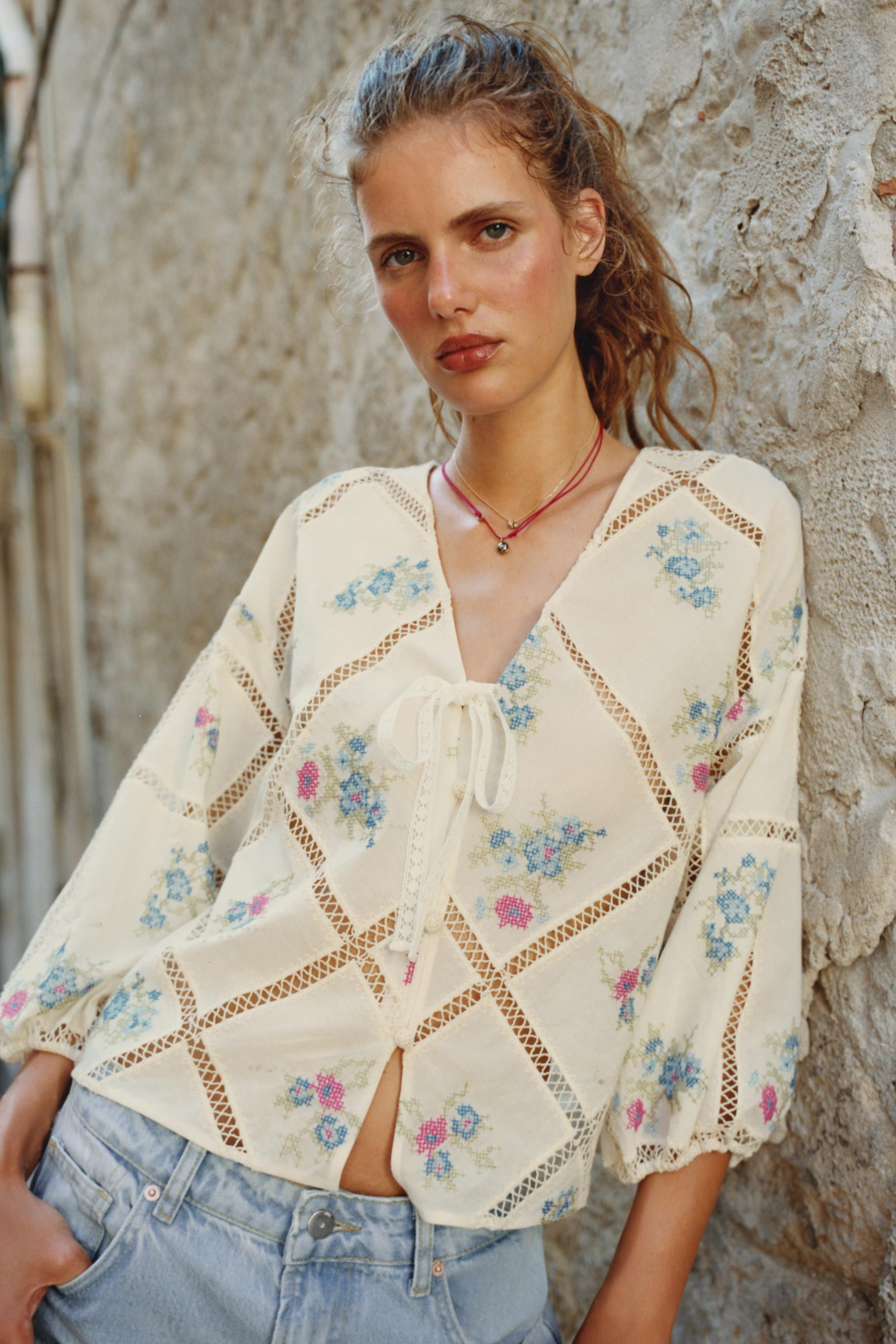 V-neck blouse with a tie detail and long balloon sleeves with elastic cuffs. Tonal ladder stitch ... | Zara US