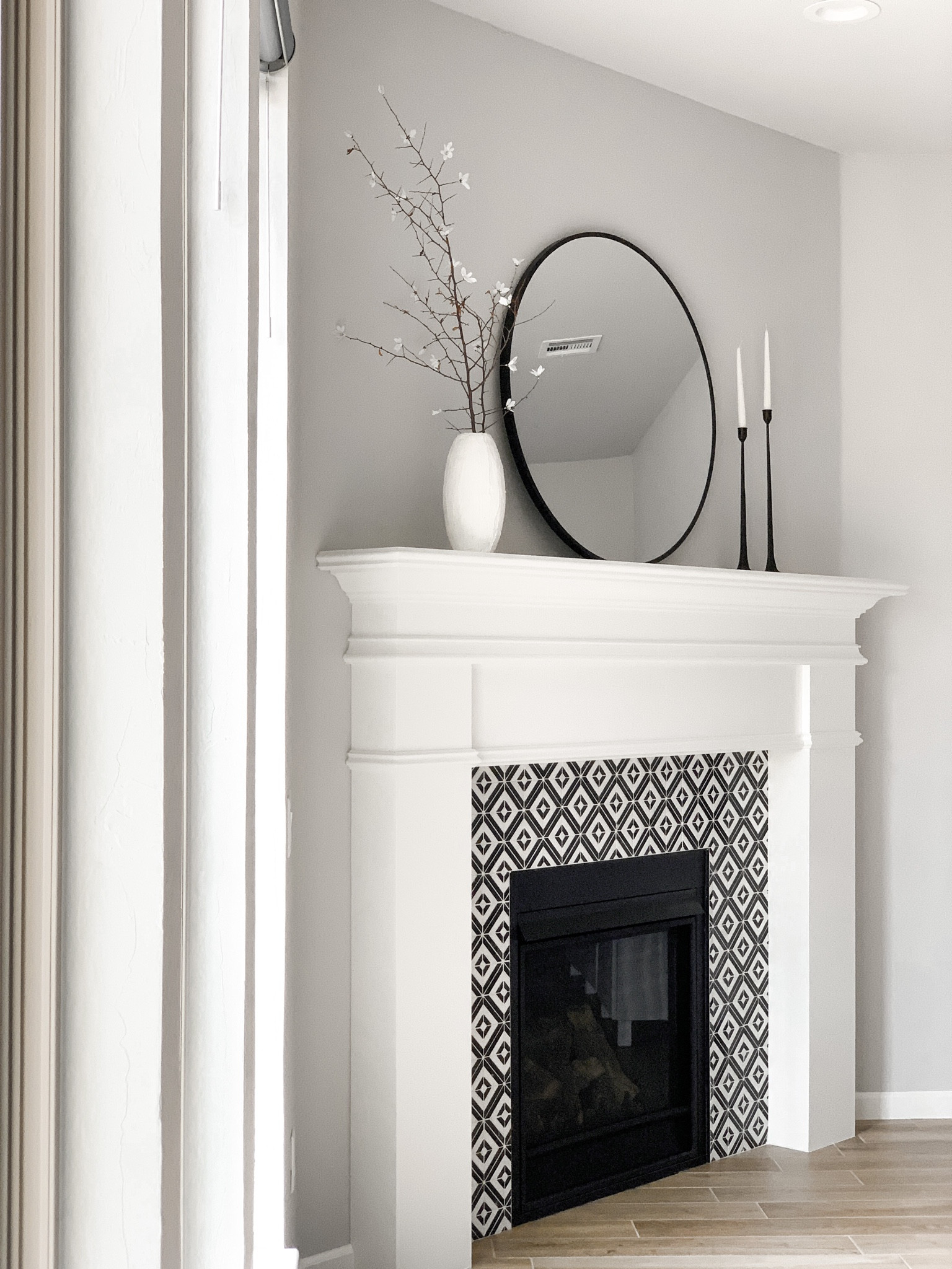 Early Spring Simple Fireplace Styling - next to tile details, linking a variety of similar choices for stems & vase

Home decor, living room decor, fireplace decor, fireplace tile, floor tile, wood tile, black candlestick holders, tapered candles, round mirror, white stems, branches, white vase 

#LTKstyletip #LTKhome #LTKSeasonal