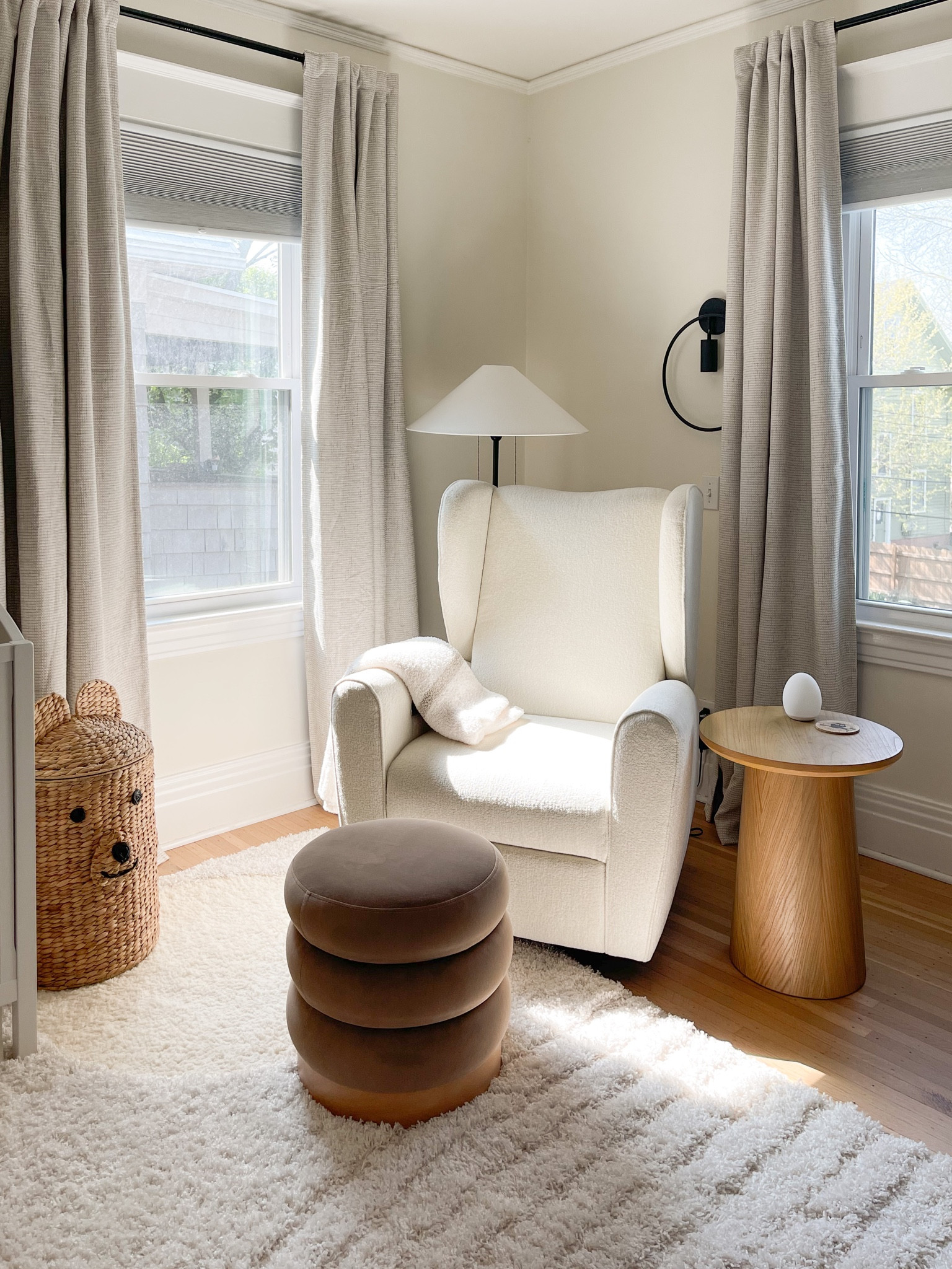 Modern minimal gender neutral nursery design
White nursery chair, wood accent table, plaid woven blackout curtains and velvet textured ottoman, black finish lighting and bear basket hamper, cozy plush rug and off white paint 

#LTKbump #LTKhome #LTKkids