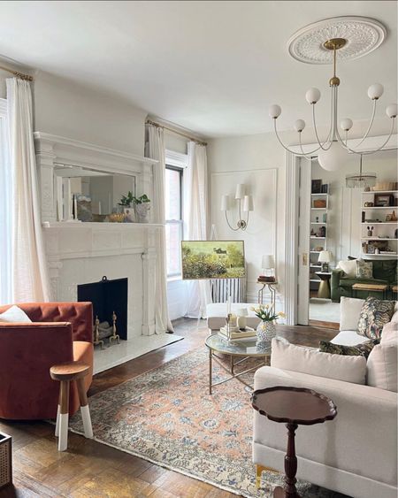 Living room decor- white sofa, swivel chair, chandelier, rug, coffee table, vase, planter, bust 

#LTKhome