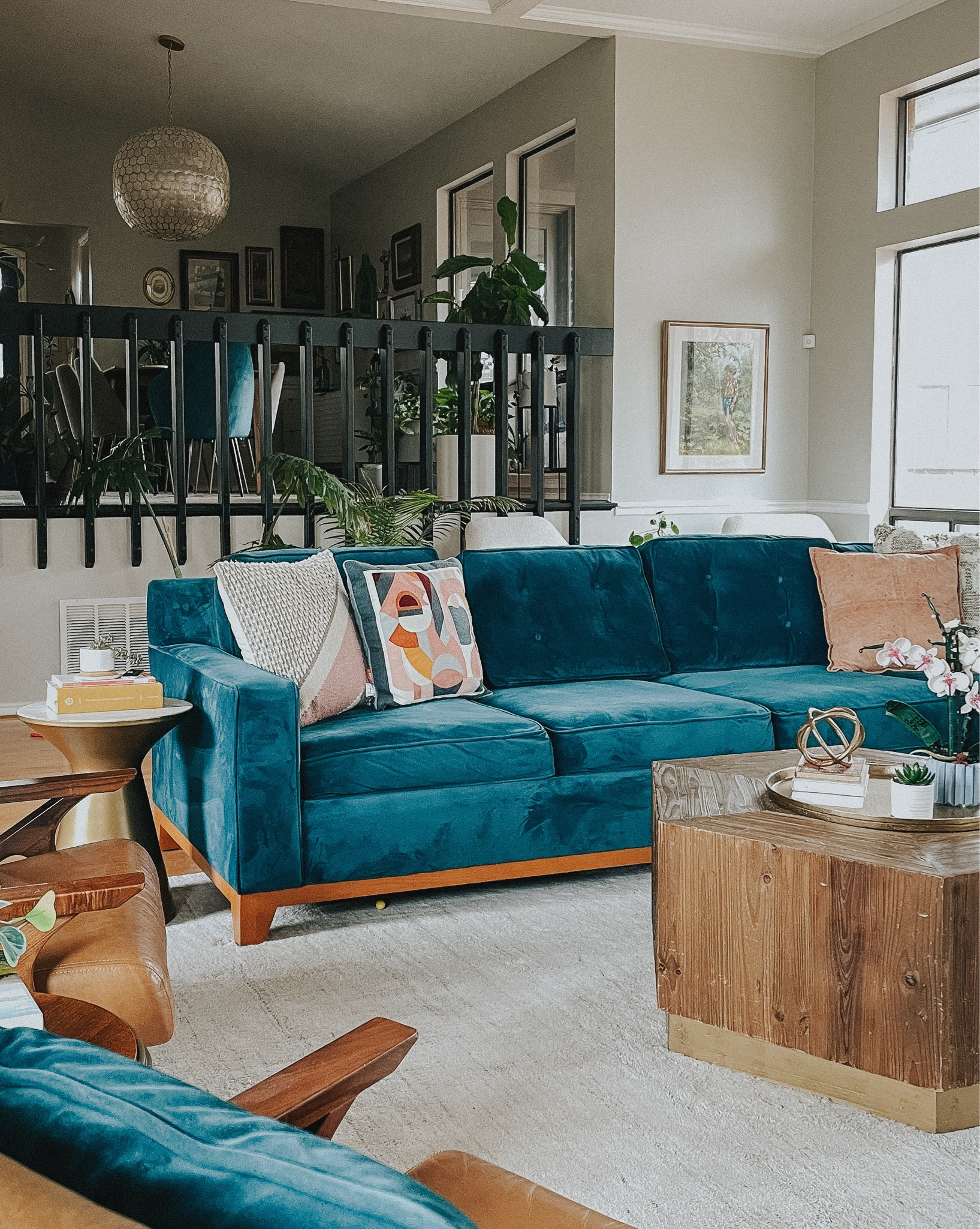 Bold, colorful living room mixed with vintage. 
Peacock blue sectional
Leather chairs
MCM chairs
Hexagonal coffee table
Arched lamp
Buffet