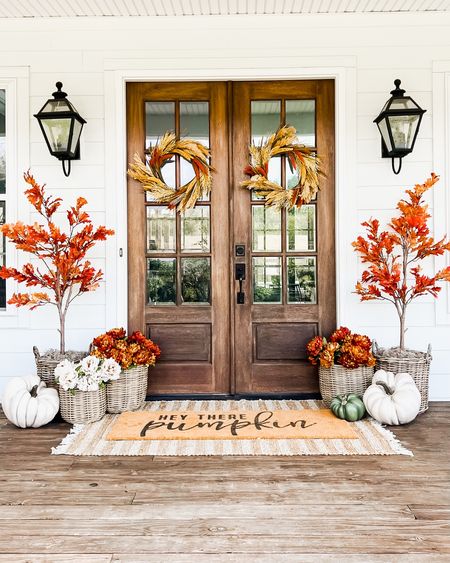 Front porch and door decor fall autumn harvest seasonal entry French double doors oversized layered scatter rug and doormat pumpkin magnolia trees faux artificial silk florals mums baskets wreaths outdoor lanterns wall sconces rocking chairs light fixtures southern modern farmhouse style home decor nearly natural amazon finds Etsy wayfair marshalls TJ Maxx home goods Walmart autumn oak trees flannel button down long sleeve Nike court legacy sneakers fall outfits maternity