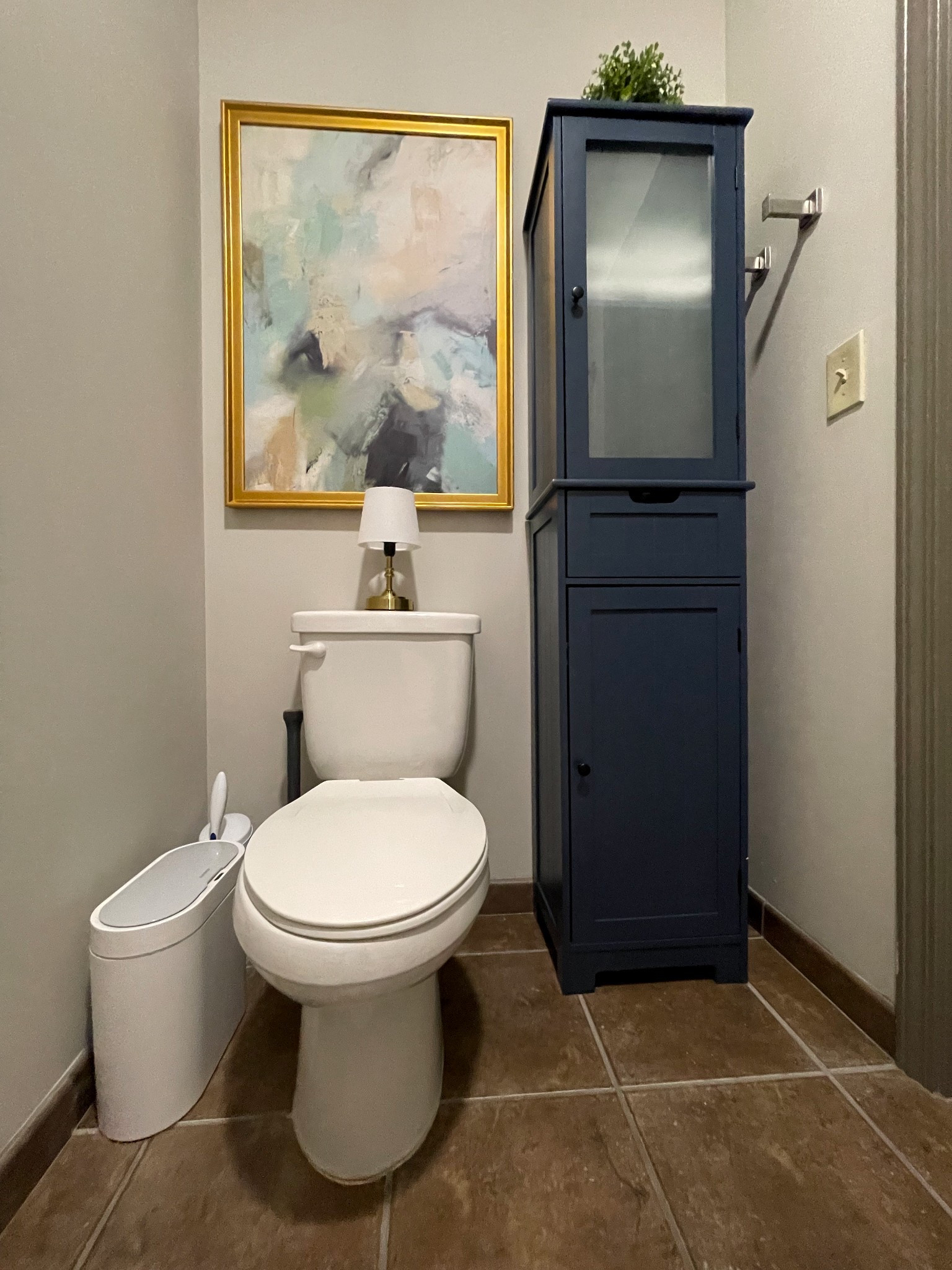 College dorm bathroom design for our daughter’s! Navy blue storage cabinet for towels and supplies, abstract art and a cordless lamp! Of course a little garbage can with automatic lid, concealed plunger and toilet bowl cleaner.🙌🏻

#LTKHome #LTKOver40 #LTKFindsUnder50