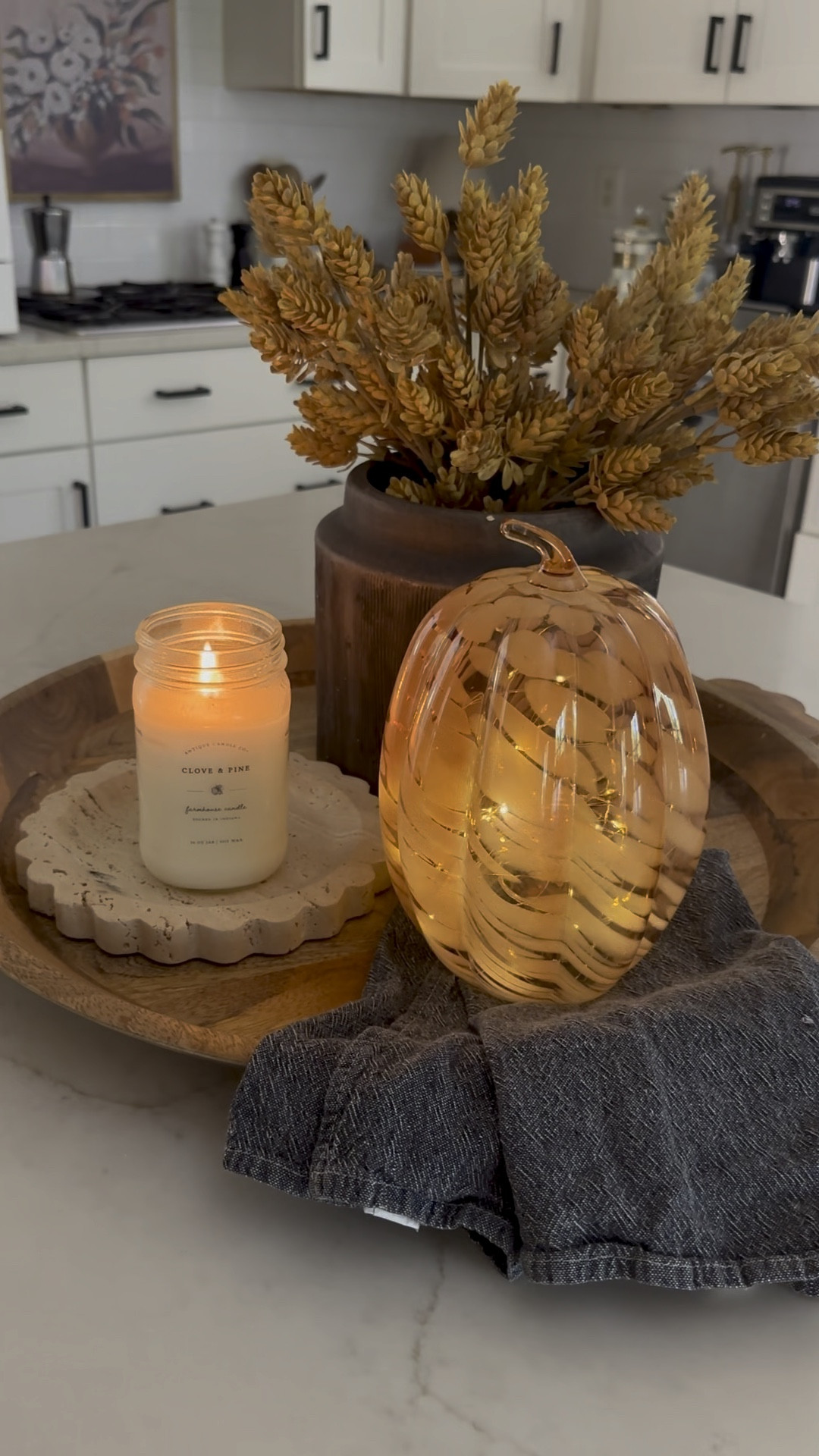 Try this easy kitchen island centerpiece formula: tray + vase with stems + candle + seasonal object + hand towel. This simple setup creates a cozy and inviting fall vibe in your kitchen! Love putting twinkle light inside these marble pumpkins! 

#LTKVideo #LTKSeasonal #LTKHome