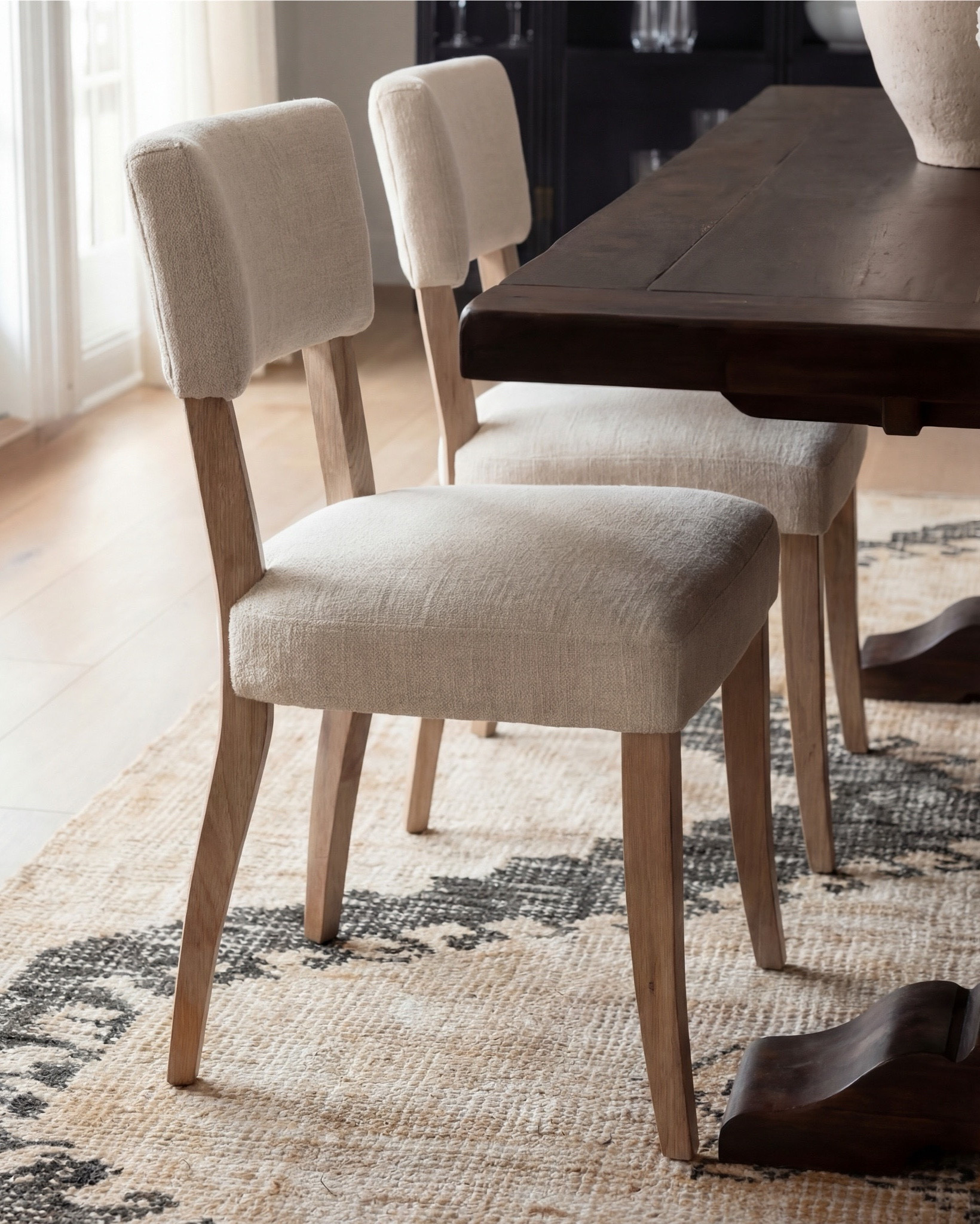 Shop the Look:
• Dark wood pedestal dining table
• Cream upholstered dining chairs with light wood legs
• Large neutral area rug with charcoal medallion pattern
• Black arched display cabinet / hutch
• Light wood sideboard / buffet cabinet
• Large ceramic floor vase (neutral tone)
• White ceramic bowl with white florals (peonies or roses)
• Pink faux cherry blossom stems in white vase
• Neutral ceramic table lamp with white shade
• Tall brass wall sconces with glass detailing
• Framed botanical artwork (set of four)
• Dark abstract wall art (large statement piece)
• White decorative vases (assorted sizes)
• Light linen curtains

#LTKhome #LTKsale #LTKstyletip