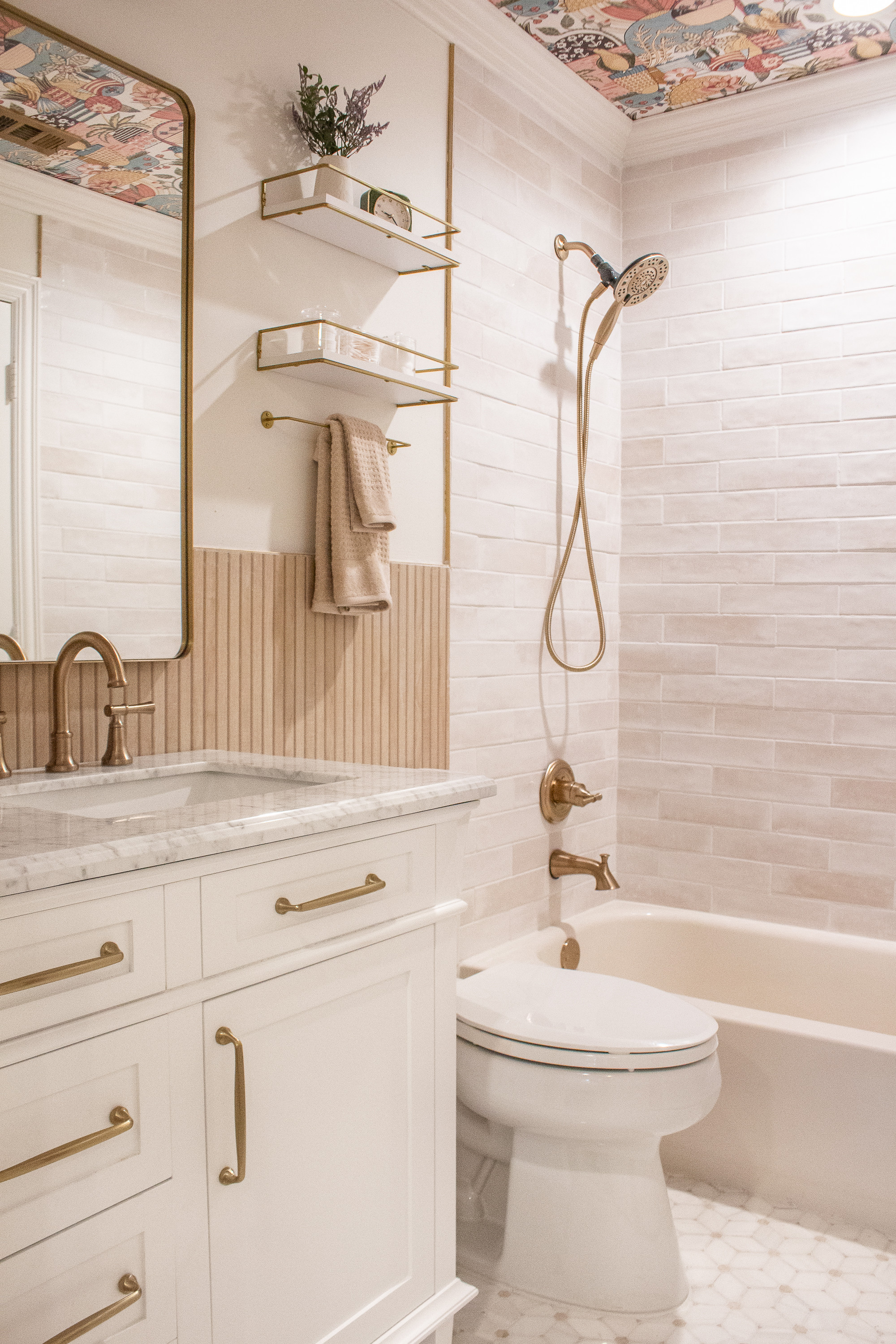 This bathroom refresh is one of my favorites. The warm brass fixtures, soft neutral tile, fluted detail, and marble countertop make the whole space feel elevated and timeless. Linking the vanity, lighting, hardware, shelves, and similar tile to help you recreate this warm, modern bathroom look.

#LTKgrwm #LTKmomlife #LTKHome