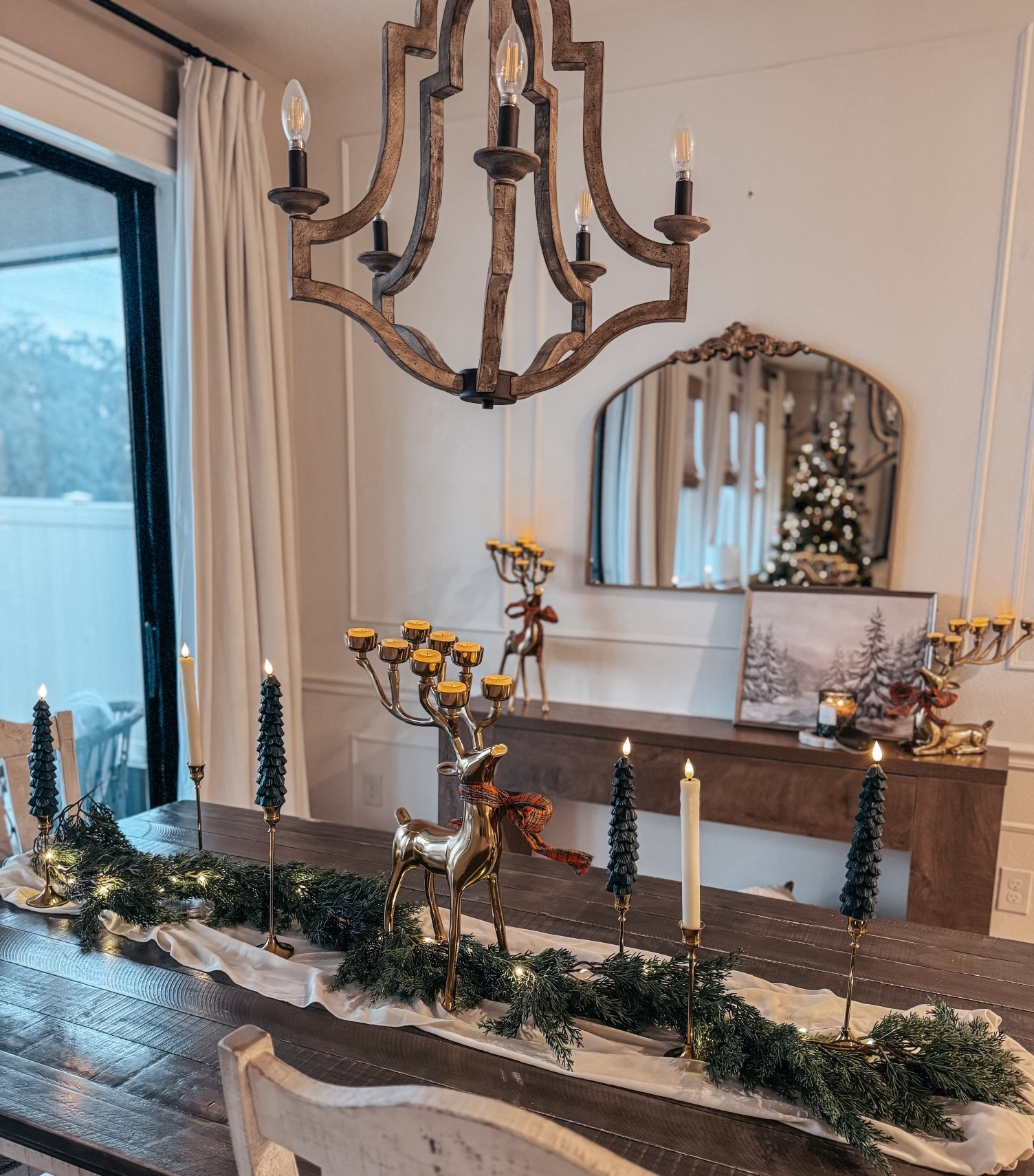 Sharing my Christmas décor tablescape—classic, warm, and full of cozy details. I used a pre-lit garland as the base, then added battery-operated Christmas tree candles and battery-operated vintage drip candles for that soft, traditional holiday glow.

Layered in a gold candle holder set, reindeer tealight holders, and a vintage gold mirror to bring height and shine. Everything sits perfectly on our wooden rustic console table under a wood chandelier for the prettiest Christmas moment.

#LTKHome #LTKHoliday #LTKFindsUnder50