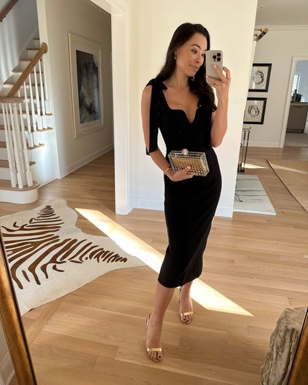 Kat Jamieson wears a black dress. Cocktail party, holiday outfit, Christmas, wedding guest dress, midi dress, gold heels, gold lucite clutch. 

#LTKwedding #LTKSeasonal #LTKHoliday