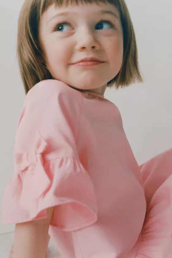 Dress with round neck and short sleeves with ruffle and bow appliqué. Teardrop button closure at... | Zara US