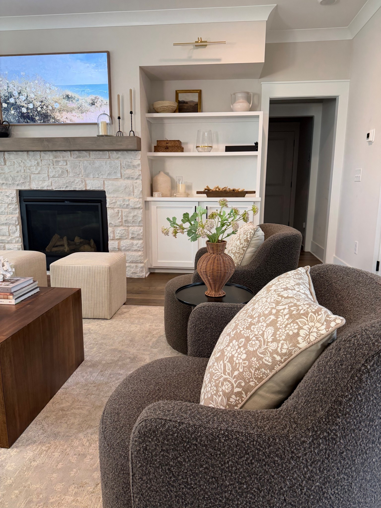 Modern transitional living room, accent chairs, boucle swivel chair, living room design, living room setup, living room furniture, swivel chairs, coffee table, frame TV, modern fireplace, stone fireplace 