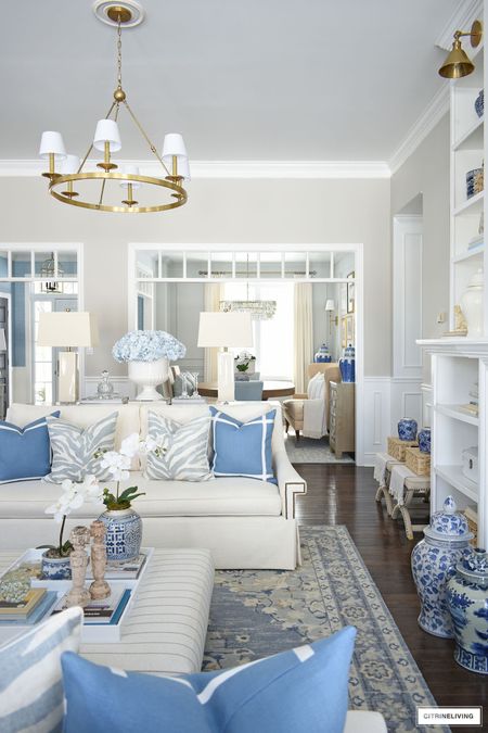Spring living room decorating! Vibrant blues with soft blues, hydrangeas, orchids, and chinoiserie 
Home decor, living room decor, coffee table, ottoman, ginger jar, white sofa, brass lighting, rug, traditional rug 

#LTKhome #LTKstyletip #LTKFind