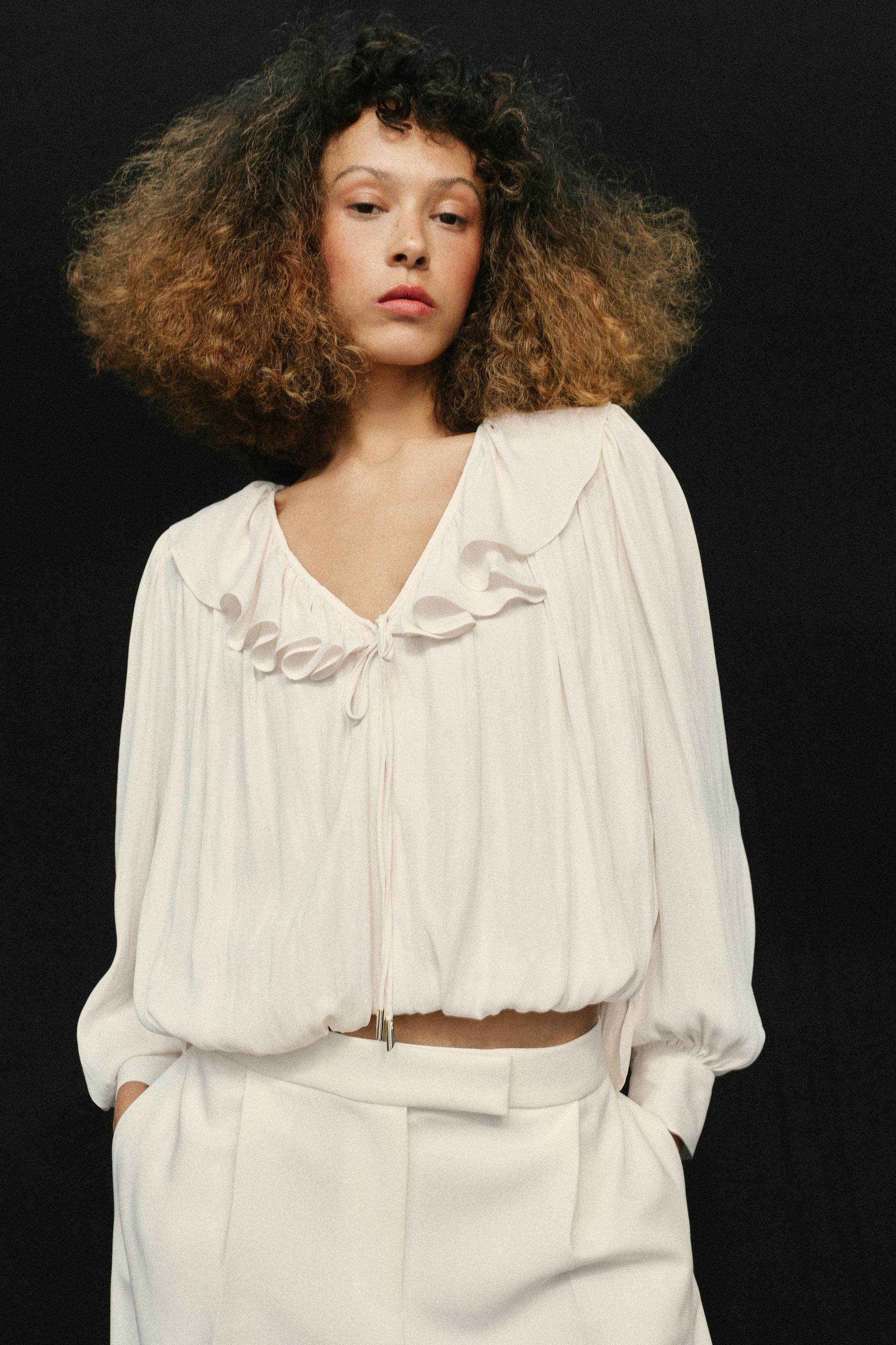 Flowy V-neck blouse with ruffles and a bow. Long sleeves with shoulder pads. Asymmetric hem and p... | Zara US