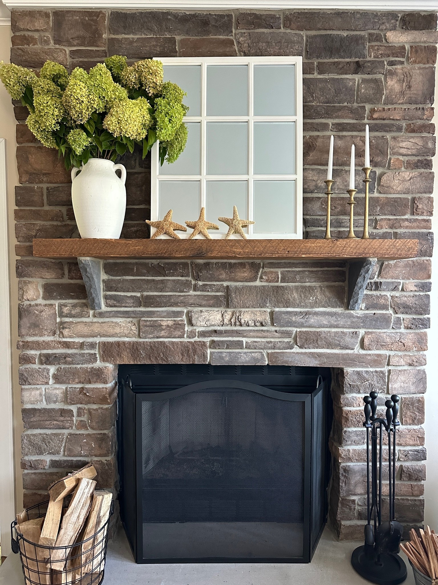 Late Summer - early Fall fireplace mantel with white vase of hydrangeas, white window pane mirror, gold candlesticks and starfish for a coastal touch!

#LTKSeasonal #LTKHome