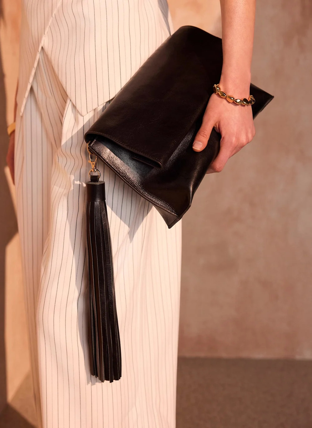 Daisy Black Leather Fold Over Tassel Clutch | Mint Velvet