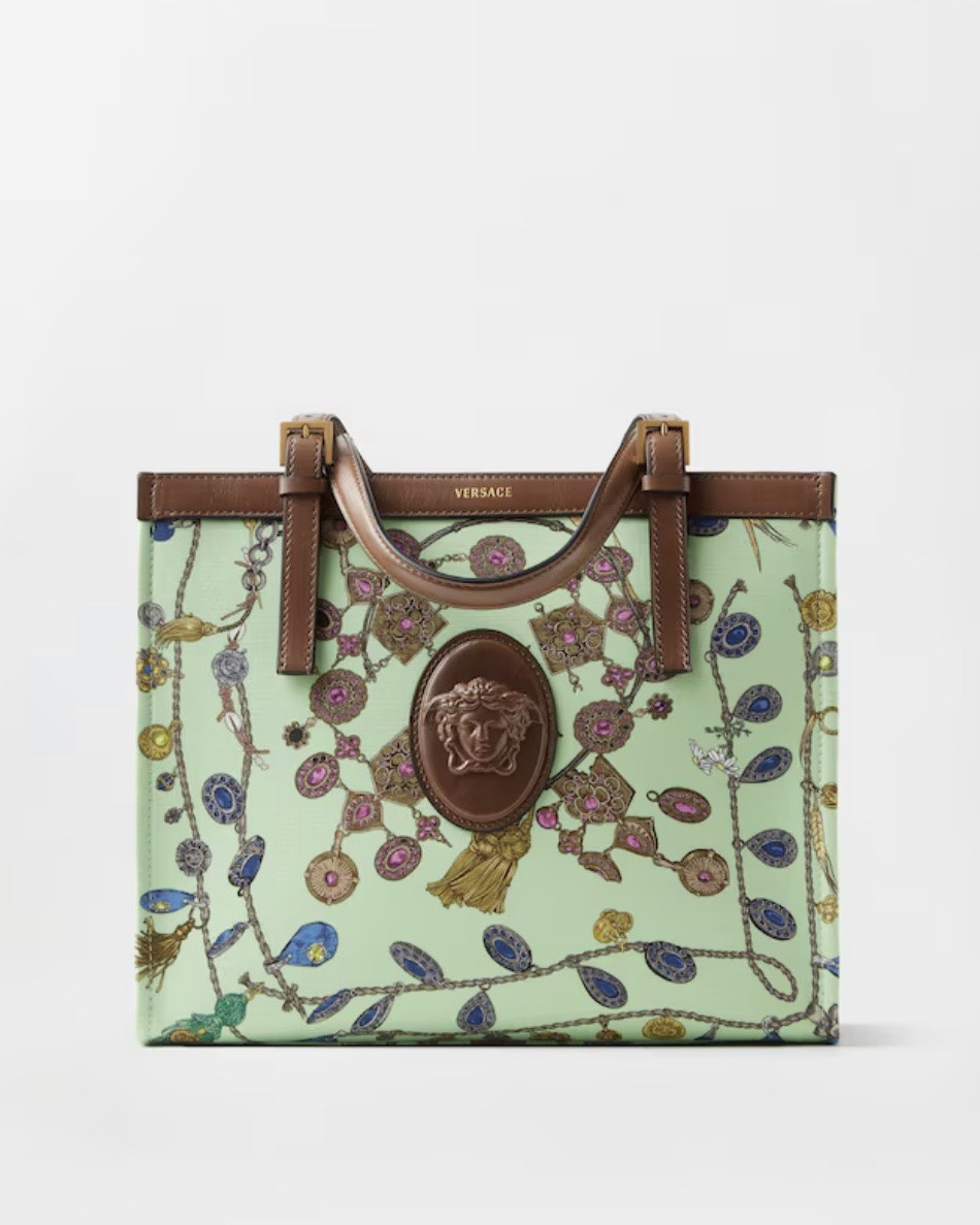 The Rivière canvas tote bag with leather trims is defined by a 'Broken Jewels' print and a central Medusa Cameo leather patch—a 3D rendition which captures the depth of Medusa's eyes and winged details in her hair. The accessory is detailed with an embossed Versace Logo, an interior zipped pocket and a magnetic leather tab closure. The style can be worn in-hand or crossbody using the detachable shoulder strap.
'Broken Jewels'
Medusa Cameo leather patch
Versace logo embossing
Adjustable top handles
Detachable and adjustable shoulder strap
One main compartment
1 interior zipped pocket
Interior protector strap
Metal feet
Outer composition: 100% Cotton
Lining: 59% Linen, 41% Cotton
Trim: 100% Calf leather
Size & Fit
L11.4 x W5.7 x H15.2" / L29 x W14.5 x H38.5 cm
Handle drop: L5.1" / L13 cm
Shoulder strap: L42.5" / L108 cm
Shoulder strap drop: L16.5-18.5" / L42-47 cm

#LTKSaleAlert #LTKdayinmylife #LTKU