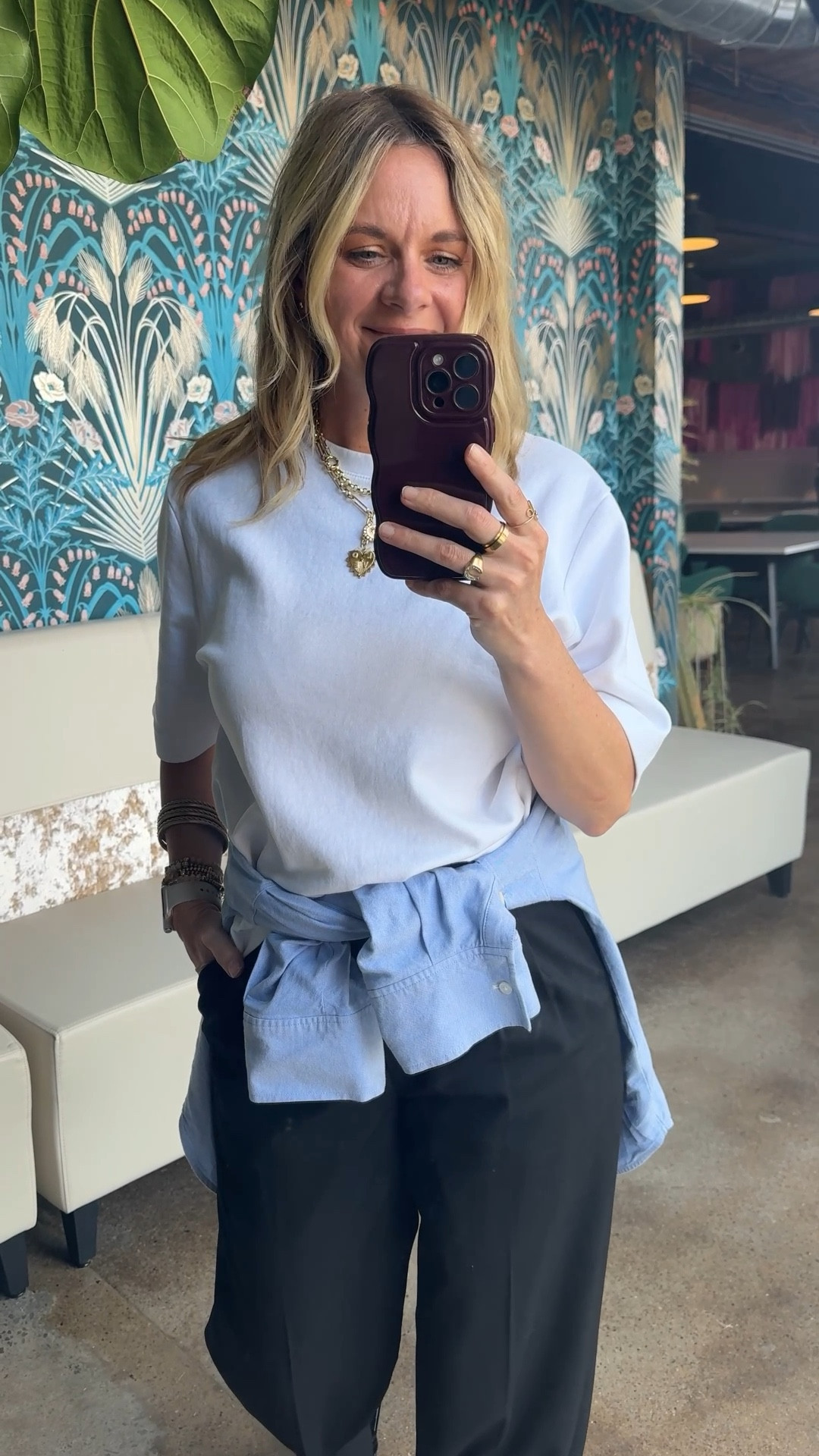 Here are 3 reasons tying a shirt around your waist is the easiest styling trick you're not using 👇

📍It defines your waist without a belt. The knot sits right at the hip and creates shape naturally — no extra accessories required.

📍It adds a layer of color or texture without adding bulk. A light blue oxford over black trousers instantly breaks up a basic palette and makes the outfit feel intentional rather than thrown together.

📍It gives you a built-in backup. Too cold inside? Untie it and throw it on. Too warm outside? Tie it back. It's the most functional styling trick in the book.

OOTD for a day at the office ✨ White tee + black trousers + light blue oxford tied at the waist + black flip flops + gold jewelry. Simple pieces, one small styling move, completely different outfit. Everything linked below! 👇

#LTKOver40 #LTKootd #LTKgrwm