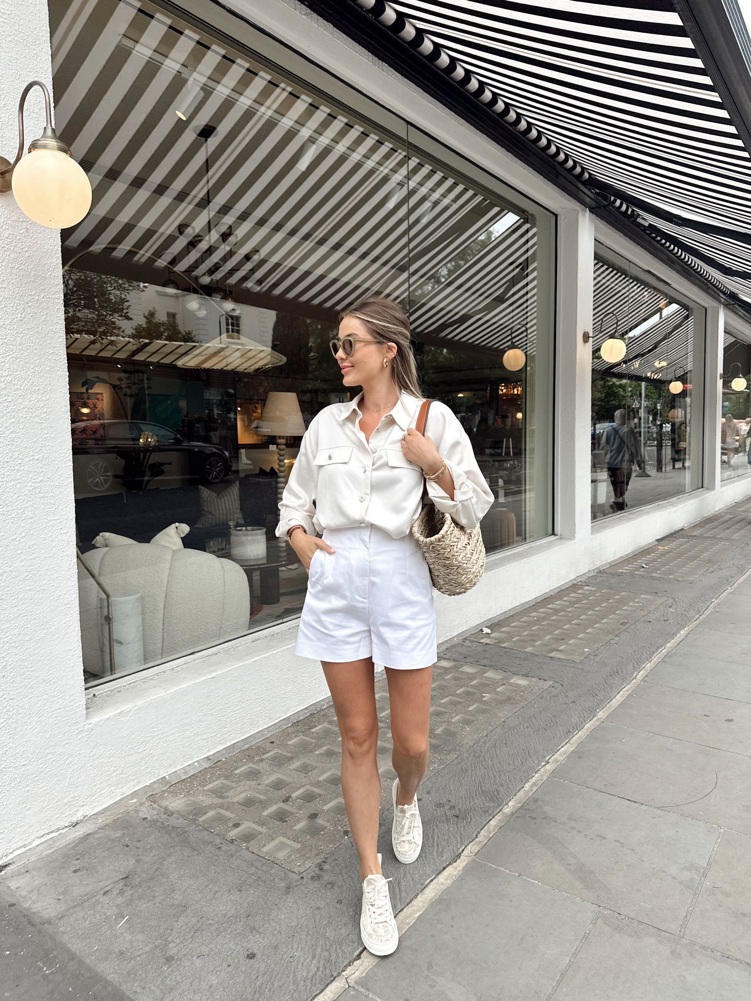 Tonal white & cream summer city outfit. Cream satin shirt with gold buttons, basket bag & white tailored shorts both from new look. Cream Chloe Lauren trainers, mulberry sunglasses (affordable dupe linked) & gold chunky hoop earrings  

#LTKstyletip #LTKFind #LTKeurope