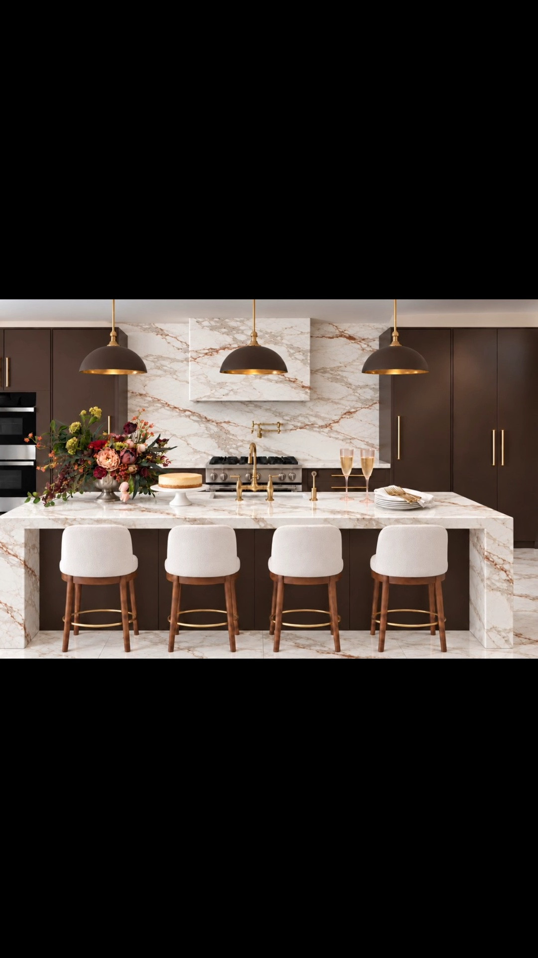 Dinner will be served here. ✨ A sleek, sophisticated kitchen made for planning your holiday get-togethers, sharing champagne, and gathering around the island.

The slab-front cabinetry is inspired by French Press Coffee, Dunn-Edwards’ 2027 Color of the Year—a deep brown with subtle plum undertones. I love how its warmth elevates the clean lines alongside the marble waterfall island and brass details.

The vintage-inspired Theo pendants feature solid brass construction and a Matte Mulberry exterior with a Brass interior. To my eye, those deep berry tones beautifully complement the cabinetry’s plum undertones.

The counter stools bring it all together with graceful silhouettes, creamy upholstery, warm wood frames, and circular brass footrests. An elevated, inviting setting for your holiday get-togethers.

#DinnerWillBeServed #ModernKitchen #KitchenDesign #KitchenInspiration #KitchenIsland #Counter #SlabCabinets #DarkBrownKitchen #FrenchPressCoffee #ColorOfTheYear2027 #Pendant #PendantLighting #KitchenLighting #CounterStools #BarStools #BrassDetails #MarbleCountertops #WaterfallIsland #KitchenAppliances #Refrigerator #Freezer #KitchenSink #KitchenFaucet #PotFiller #KitchenRange #Stove #FloralArrangement #CakeStand #ChampagneGlasses #Entertaining #Holiday #HolidayGetTogether #HolidayEntertaining #GatheringSeason #LTKHome #LTKStyleTip

#LTKSeasonal #LTKHome #LTKSaleAlert