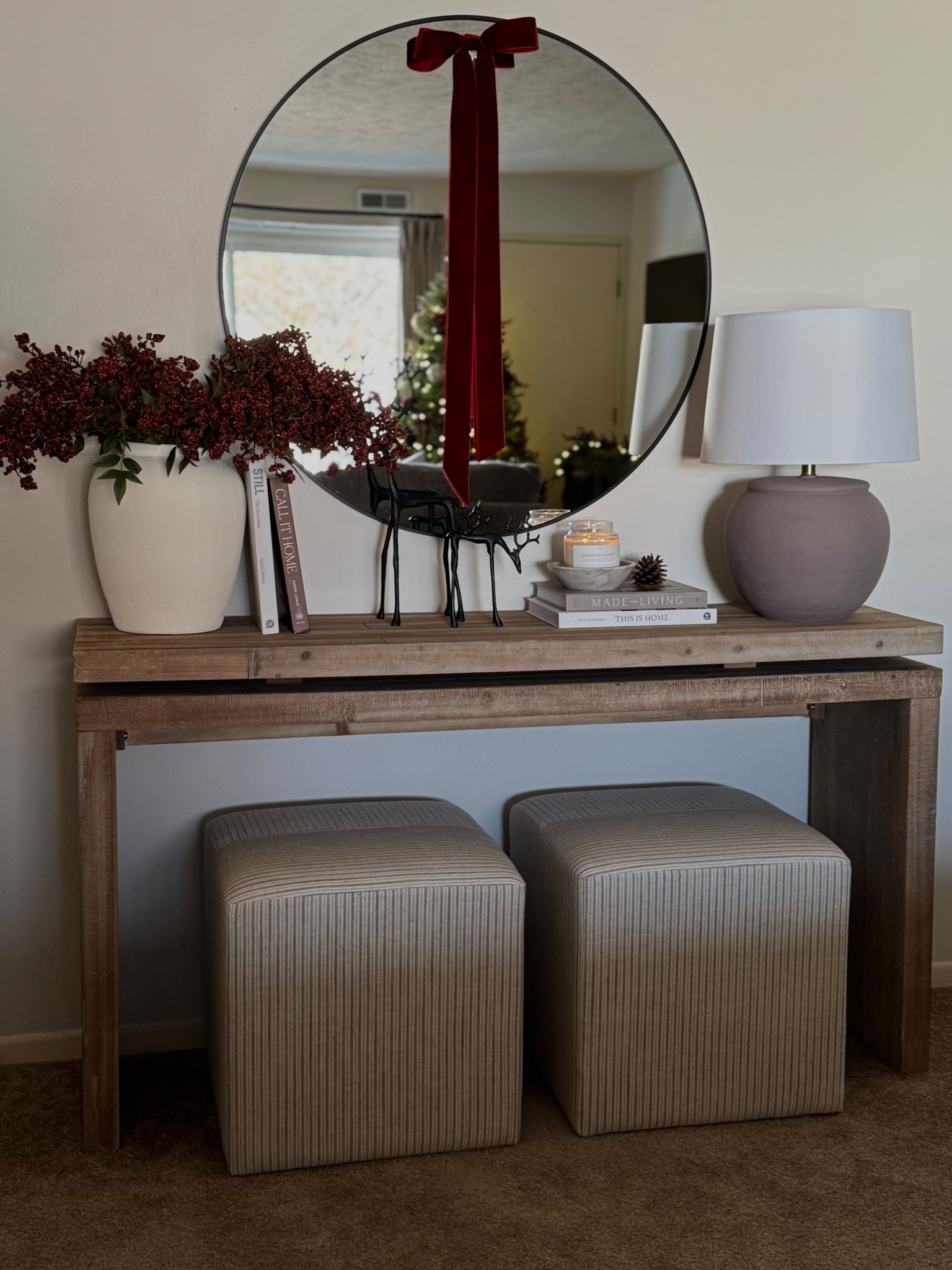 Christmas console table, red berry nandina, wood console table, Christmas decor, white vase, burgundy velvet ribbon, stripe ottomans, candle bowl, bronze reindeer, round mirror 

#LTKSaleAlert #LTKHome #LTKHoliday
