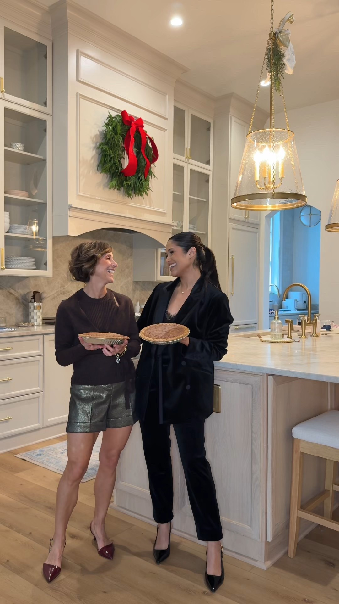 We’re both wearing holiday looks from @WHBM— I absolutely love this matching velvet pants and blazer set that you can also wear as separates and heels and lace tank are also from WHBM too. My mom is wearing a super cute wrap sweater in the espresso color and we styled it with some metallic shorts and a pair of beautiful Merlot heels. 