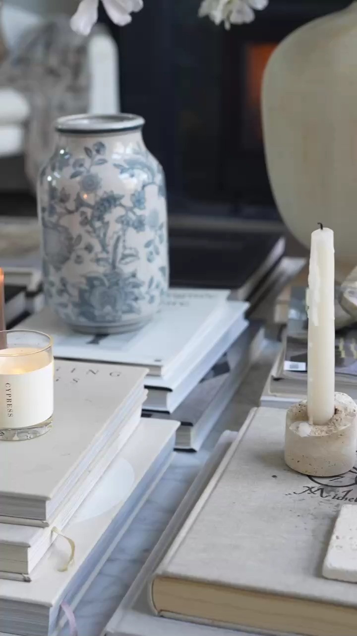 OMG this styled coffee table moment has me freaking out in the best way. The stack of design books, the vintage inspired blue and white ginger jar, and the warm candlelight create the most beautiful layered home decor look. I love building these cozy living room details that feel timeless, curated, and full of texture. It’s the little styling moments like this that make a home feel so special.  

 #LTKSpringSale #LTKSeasonal #LTKHome