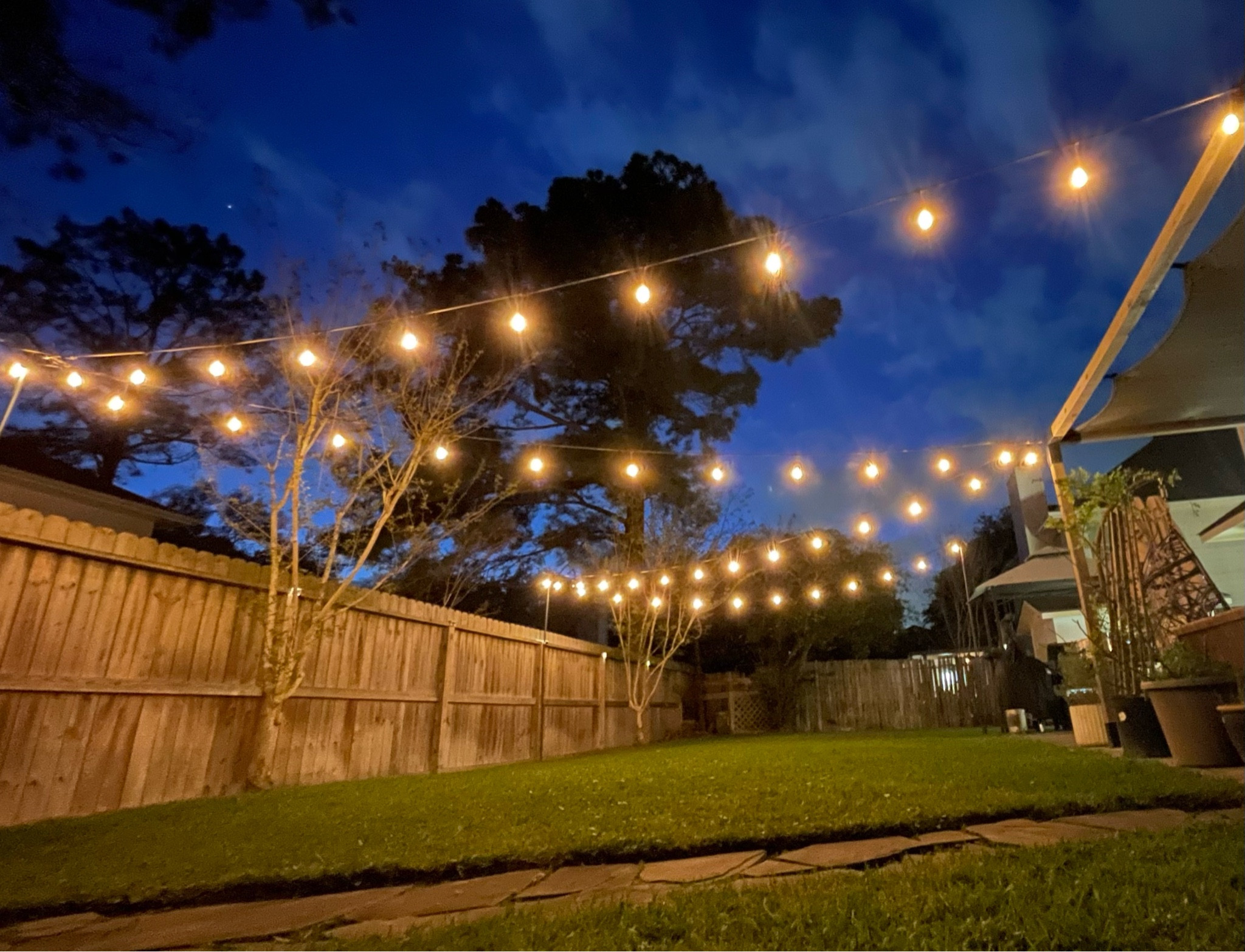 I lit up our outdoor space by rehanging, our outdoor café lights in a zigzag pattern, but this time I upgraded the hangers to heavy duty string light poles that securely stake into the ground. 

I also added water resistant protective covers for the outdoor plug connections. The lights that I am using in the back yard as well as the extension cords are all water resistant however, I have these leftover from waterproofing, holiday, decorations and thought why not put them to use?!

To take it to the next level- I added a smart outdoor plug (which has one of the best apps for controlling smart devices that I have ever used!!). The app allows me to program routines and schedules for my lights to turn on and off, and they can also be controlled by voice using our Alexa devices. In the late evenings, I never have to worry about turning the lights off myself, they will either go off at the time that they are supposed to or when we choose to shut them off. I am a big fan of smart devices inside of my home, it only makes sense to utilize them outside as well!

This has transformed the ambience in our backyard and patio space. The family cannot wait to enjoy the outdoors more during this spring and summer season. 

#LTKhome