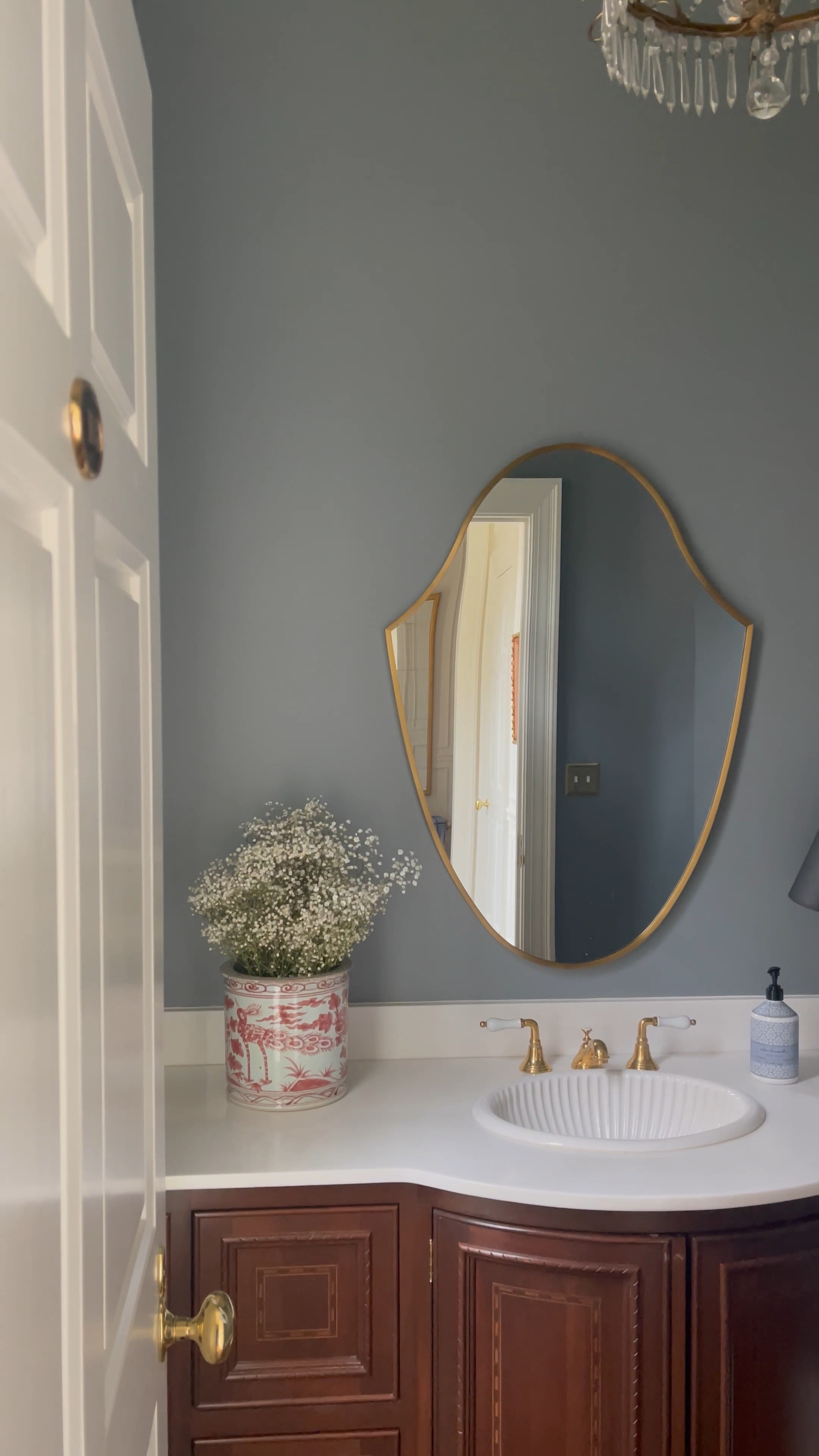Powder bathroom design, chinoiserie vase, brass shield mirror, crest mirror 

#LTKhome #LTKFind